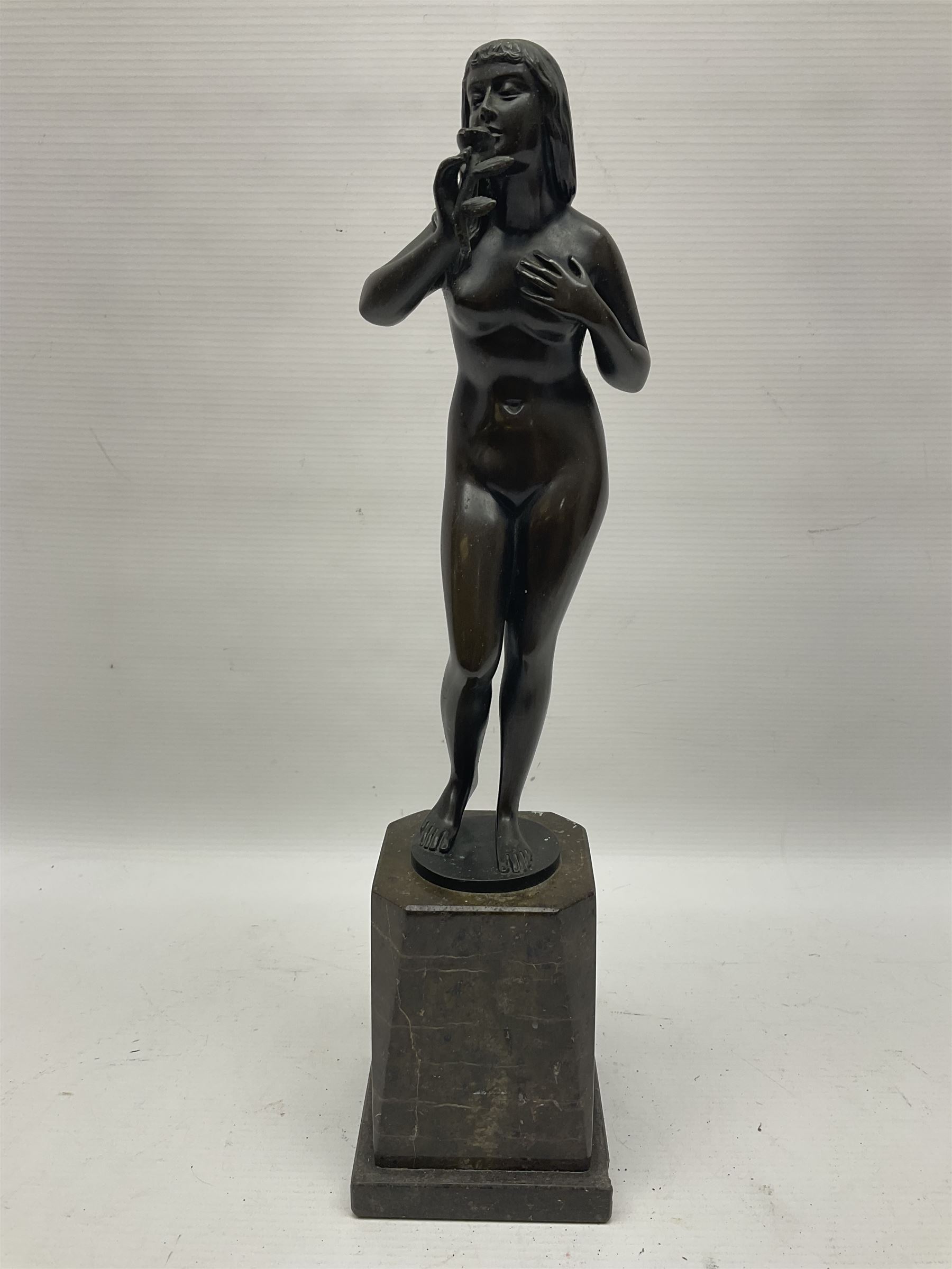 Bronze nude female figure holding a rose, upon a stone plinth, H40cm 