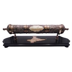 Late 19th/early 20th century Indian silver scroll holder, of cylindrical form with vacant cartouche and embossed with figures, animals and huts, upon a shaped ebonised stand with silver supports and silver panel of India, scroll L41cm, approximate weight of scroll 14.89 ozt (463.3 grams)