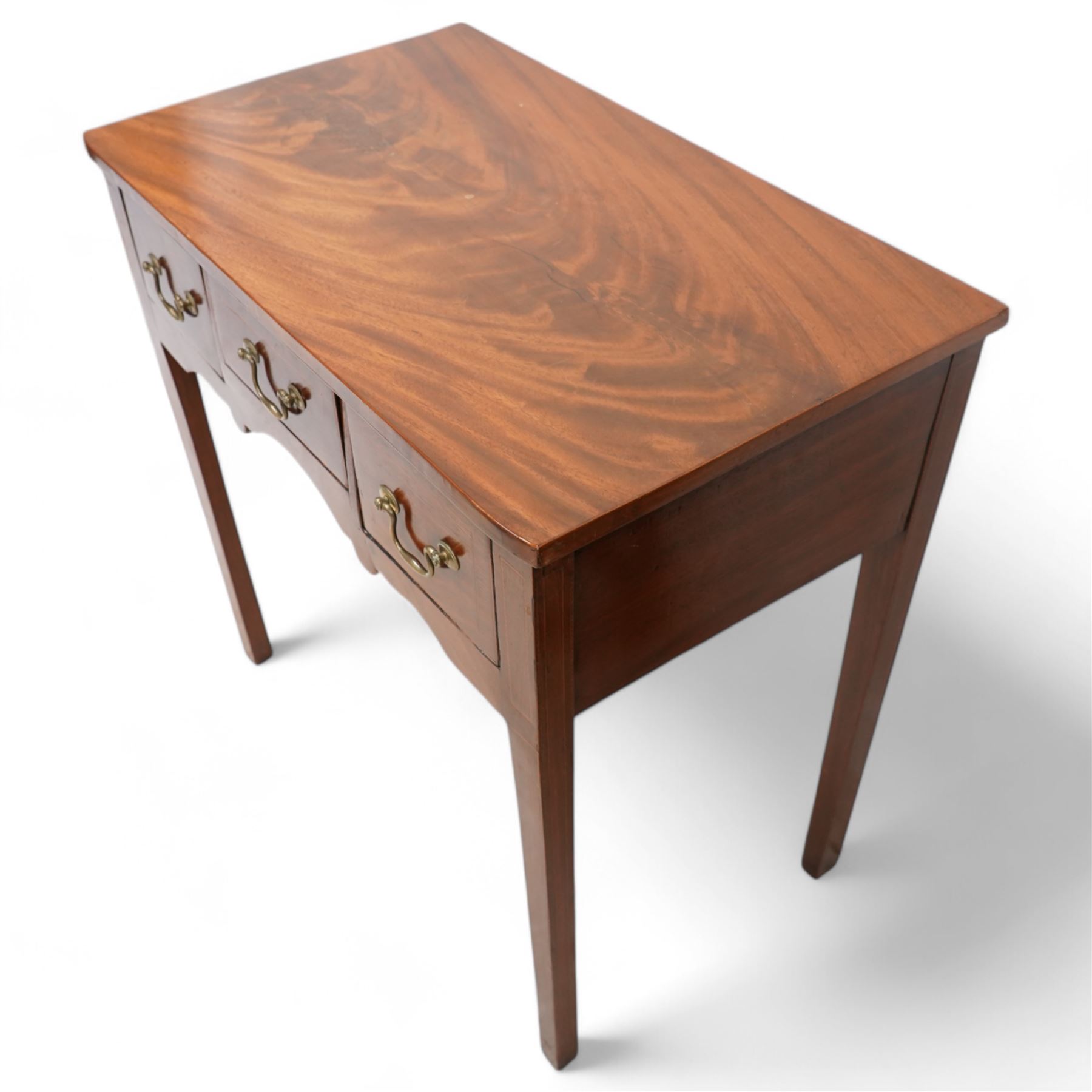 George III inlaid mahogany low-boy, shaped rectangular top with banded edge, fitted with three drawers inlaid with boxwood stringing over a shaped apron, raised on square supports with inner chamfer