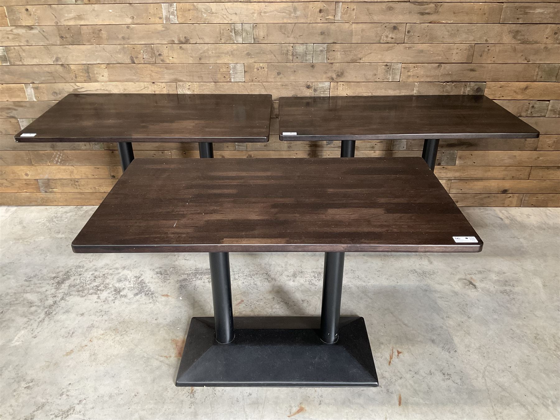 Three dark walnut rectangular console restaurant tables, on black metal bases