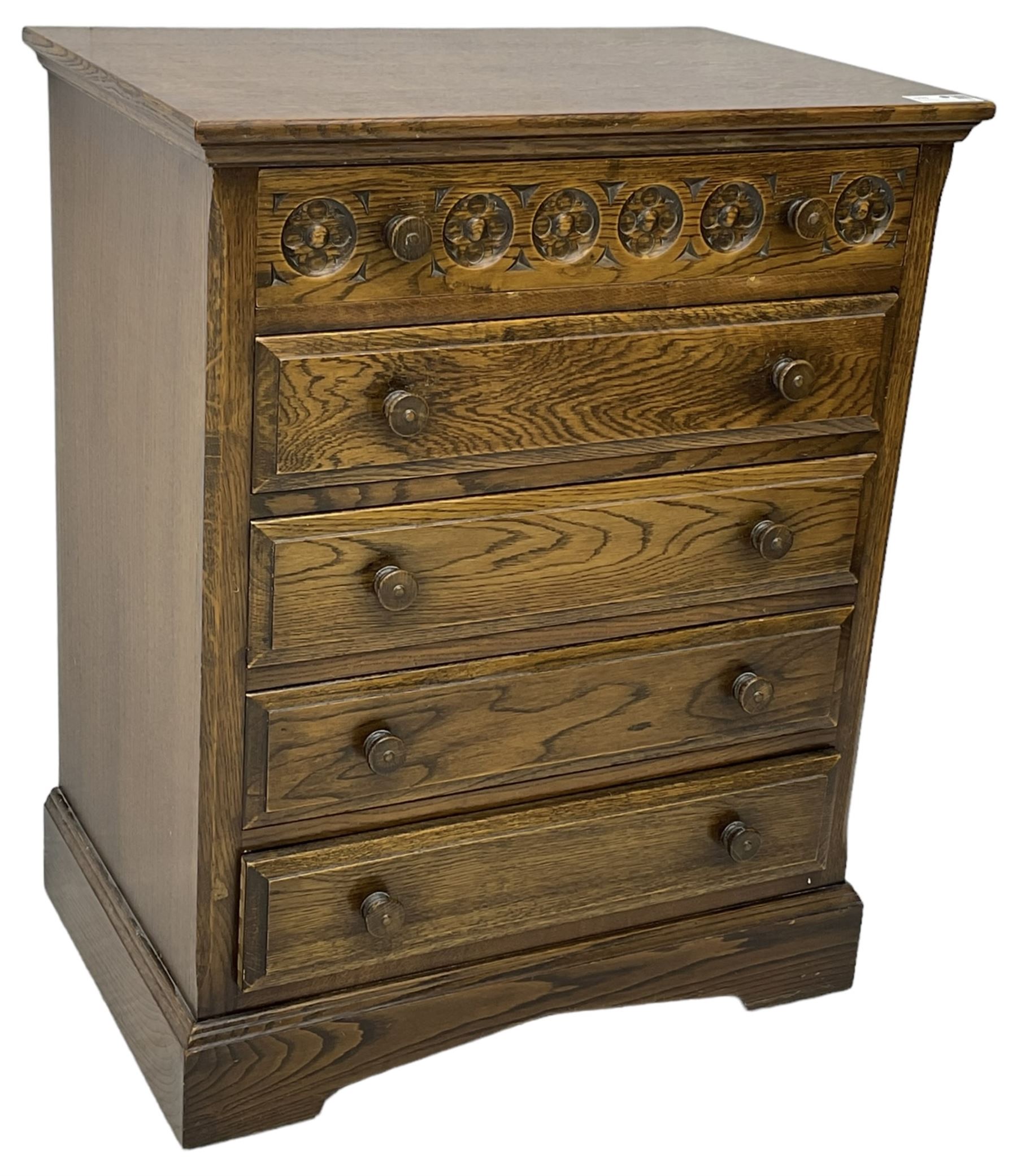 Mid-20th century oak chest, fitted with five drawers, the top drawer carved with flower head roundels, on bracketed plinth base 