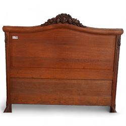 Late 19th century French oak double bedstead, headboard with shaped rail and carved pediment, carved footboard