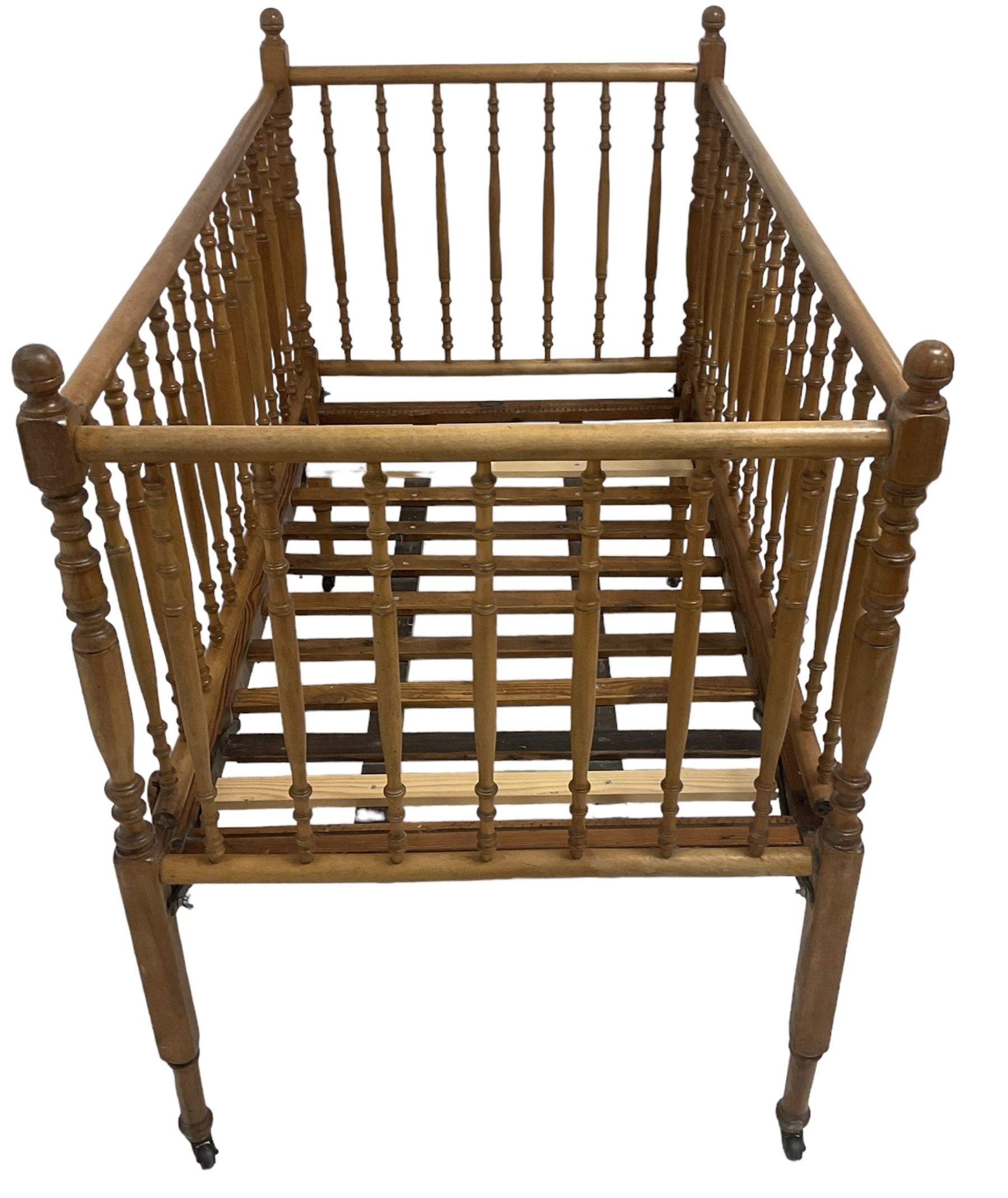 Victorian beech and pitch pine crib, turned spindle gallery supports, raised on square tapering supports with castors