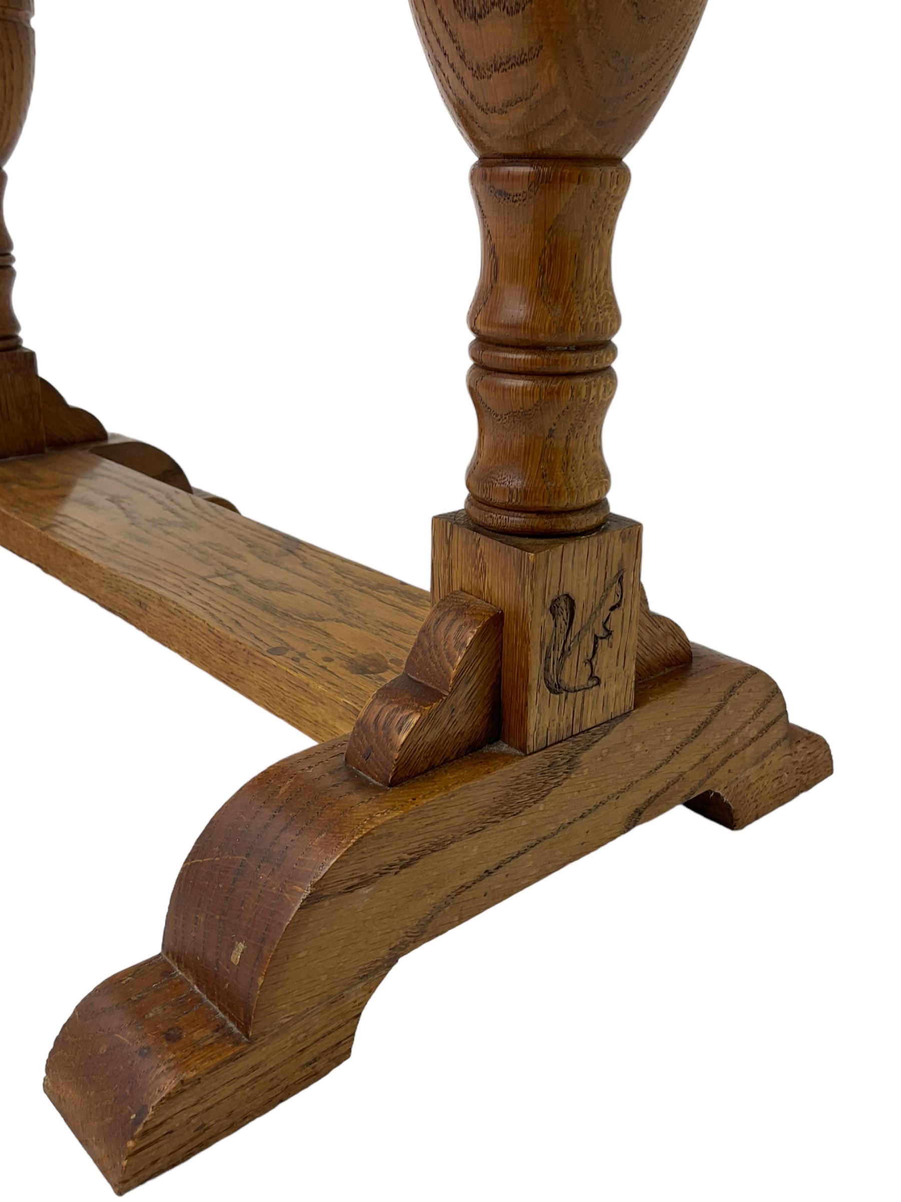 20th century oak occasional table, rectangular top on turned twin pillar supports, carved with squirrel motif, on shaped sledge feet united by stretcher 