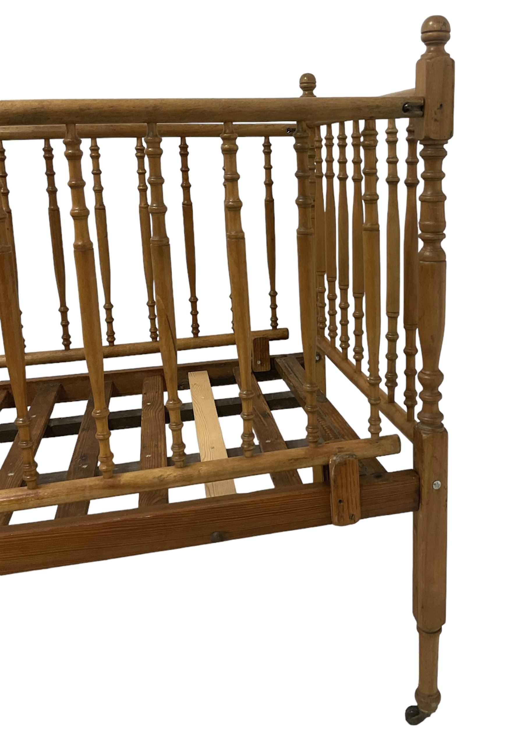 Victorian beech and pitch pine crib, turned spindle gallery supports, raised on square tapering supports with castors