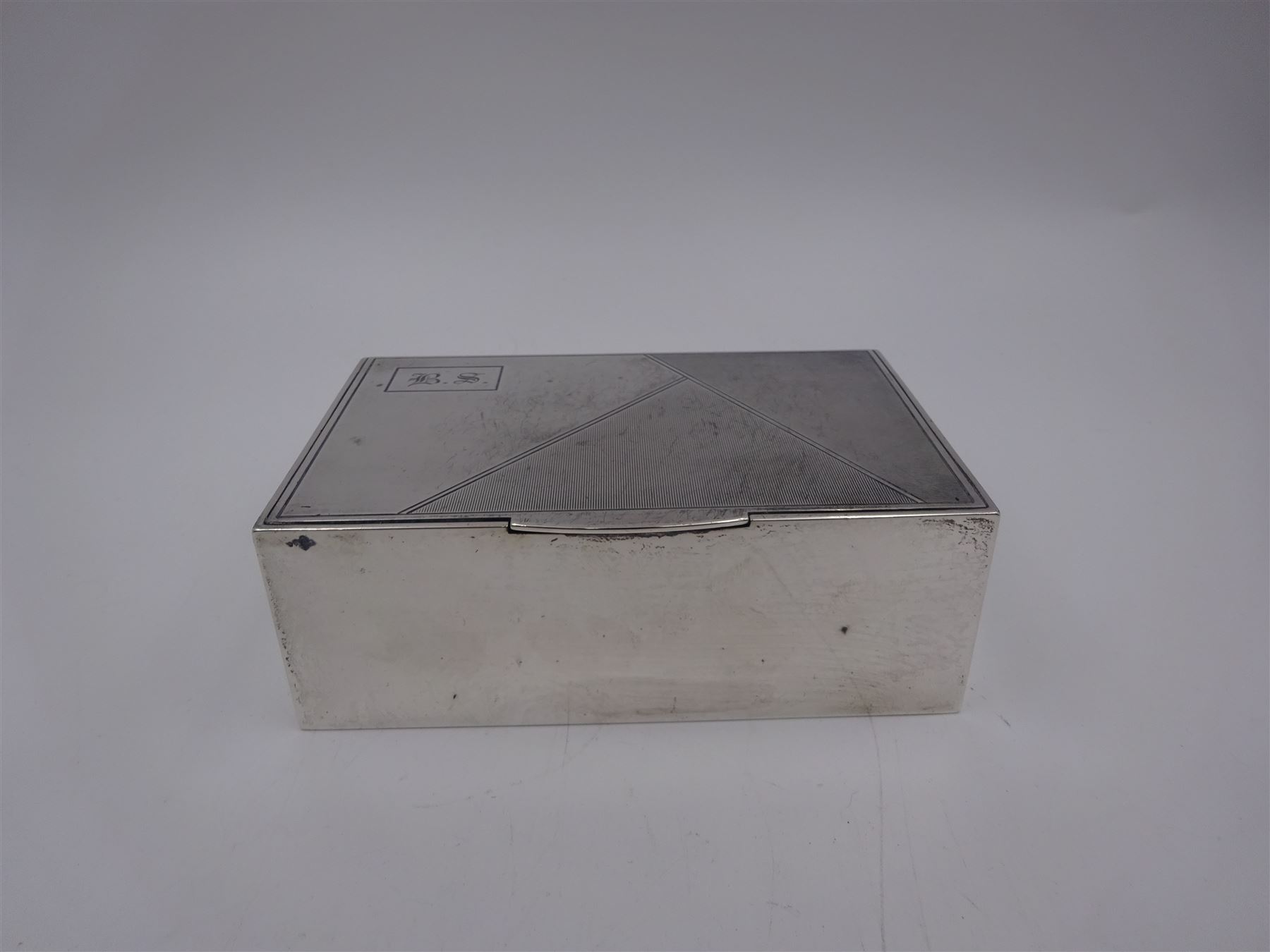 1930s silver mounted cigarette box, of rectangular form, with engine turned decoration and engraved cartouche to hinged lid, opening to reveal a softwood interior, hallmarked London 1930, maker's mark worn and indistinct