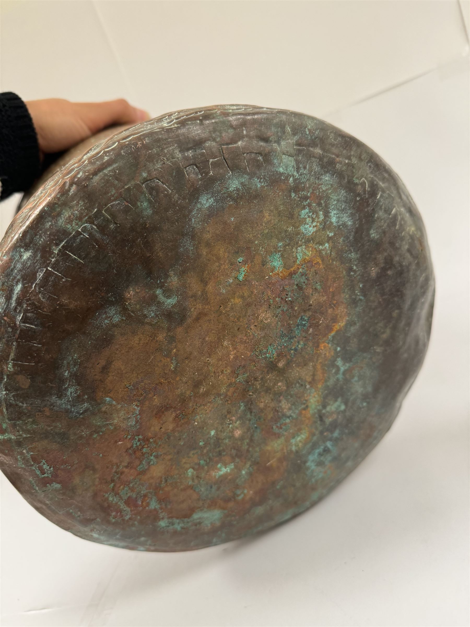 Middle eastern copper bucket, with chased and embossed band of animal decoration, together with a copper jardinière embossed with floral panels, copper plate with embossed leaf motif and two brass helmet shaped coal scuttles, bucket H26cm