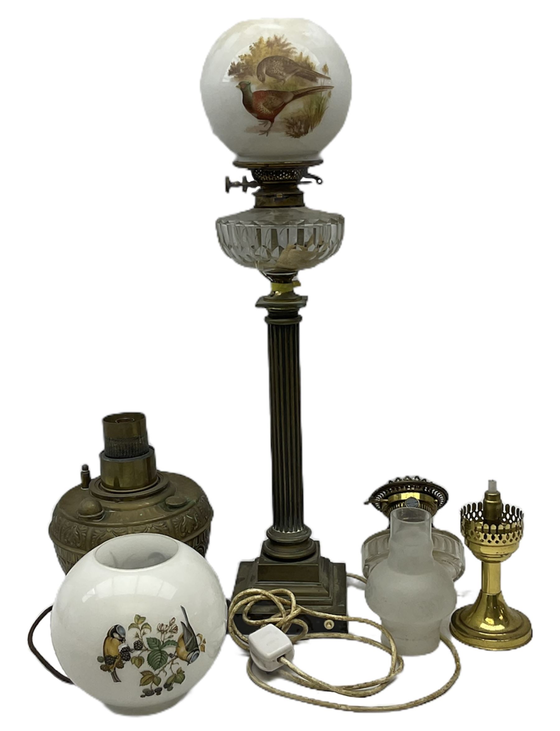 Victorian brass oil lamp converted to electricity, the square stepped base with a reeded doric column leading to a cut clear glass reservoir and burner and spherical shade with printed bird decoration, together with another similar shade and oil lamp parts and accessories etc