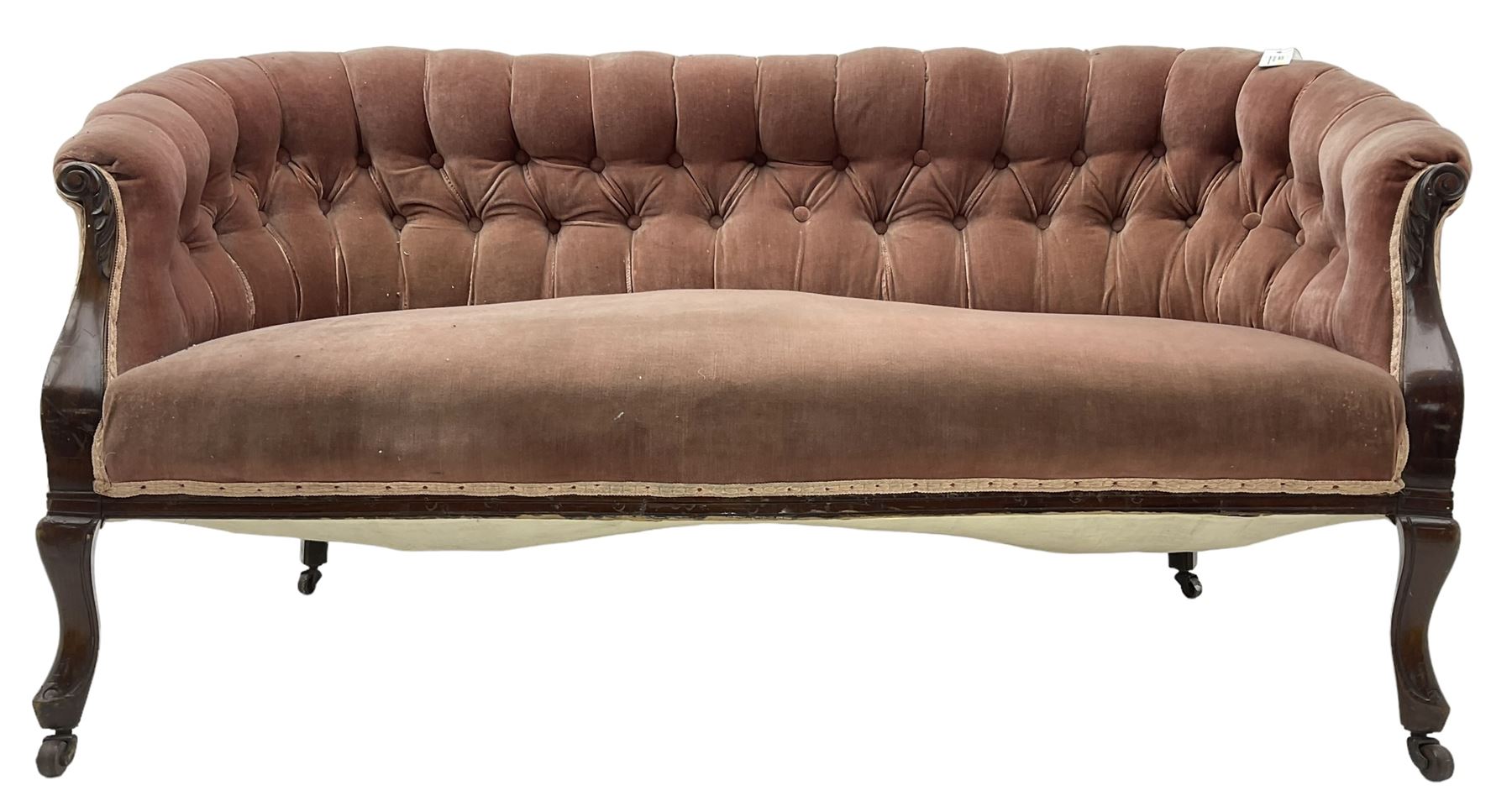 Late 19th century mahogany framed two-seat sofa, upholstered in buttoned pink fabric, on cabriole front supports, on castors 