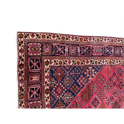 Persian Joshaghan red ground rug, the medallion, field and spandrels decorated with Pitrak and tree of life motifs, the border with repeating design decorated with stylised plant motifs, within guard stripes