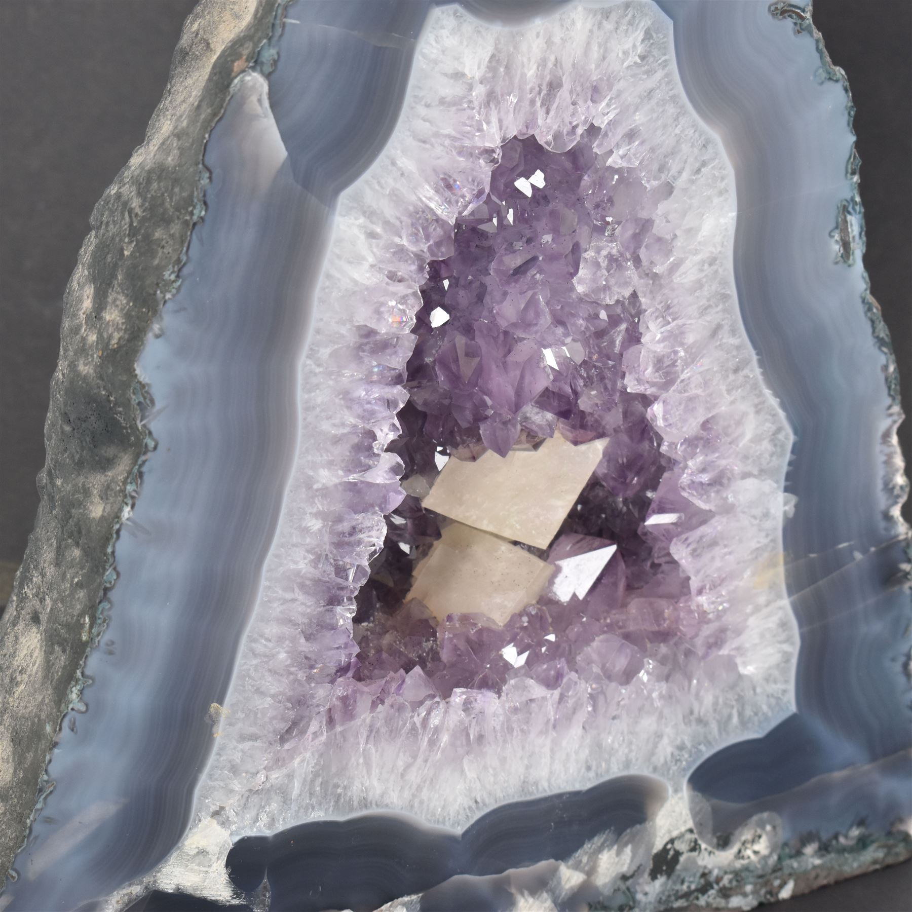 Amethyst crystal ‘cathedral’ geode, free standing with flat base and prepared outer surface, with well-defined crystals of various sizes within the cavern, H25cm, W25cm