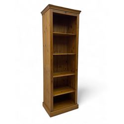 Narrow pine open bookcase, projecting moulded cornice over four open shelves, on plinth base