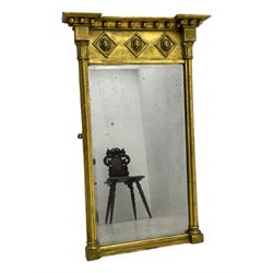 Regency giltwood and gesso pier mirror, projecting moulded cornice with globular mounts, the frieze decorated with three lion masks within lozenges, cluster column uprights with leaf decorated capitals, bevelled mirror plate