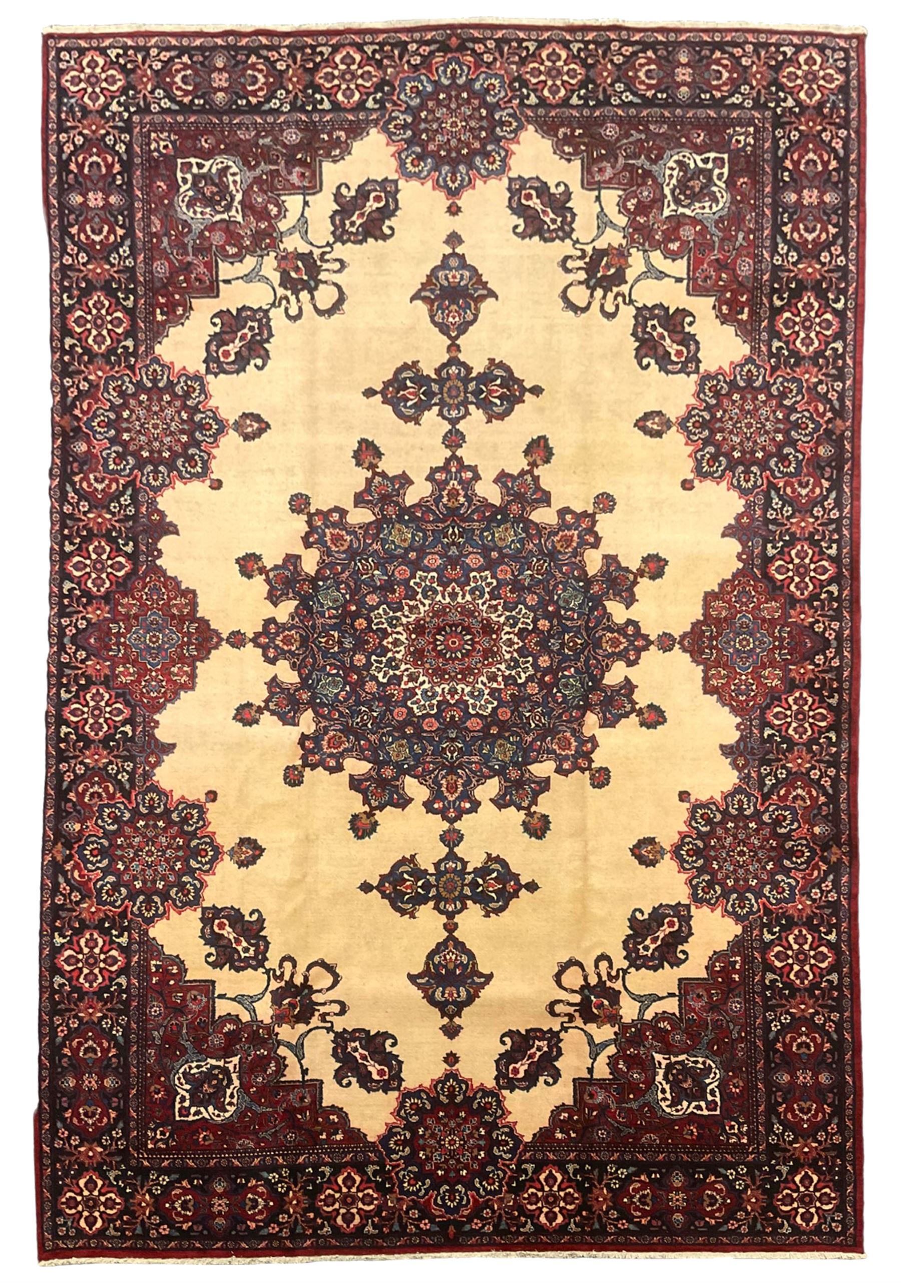 North East Persian Meshed carpet, the field with large central medallion decorated with stylised plant motifs, the field surrounded by panels, medallions and spandrels decorated with floral motifs, indigo ground border with overall floral design 