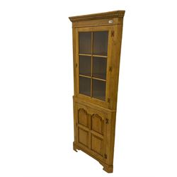 Traditional light oak corner cabinet, projecting cornice, dentil frieze, single glazed door above single fielded door