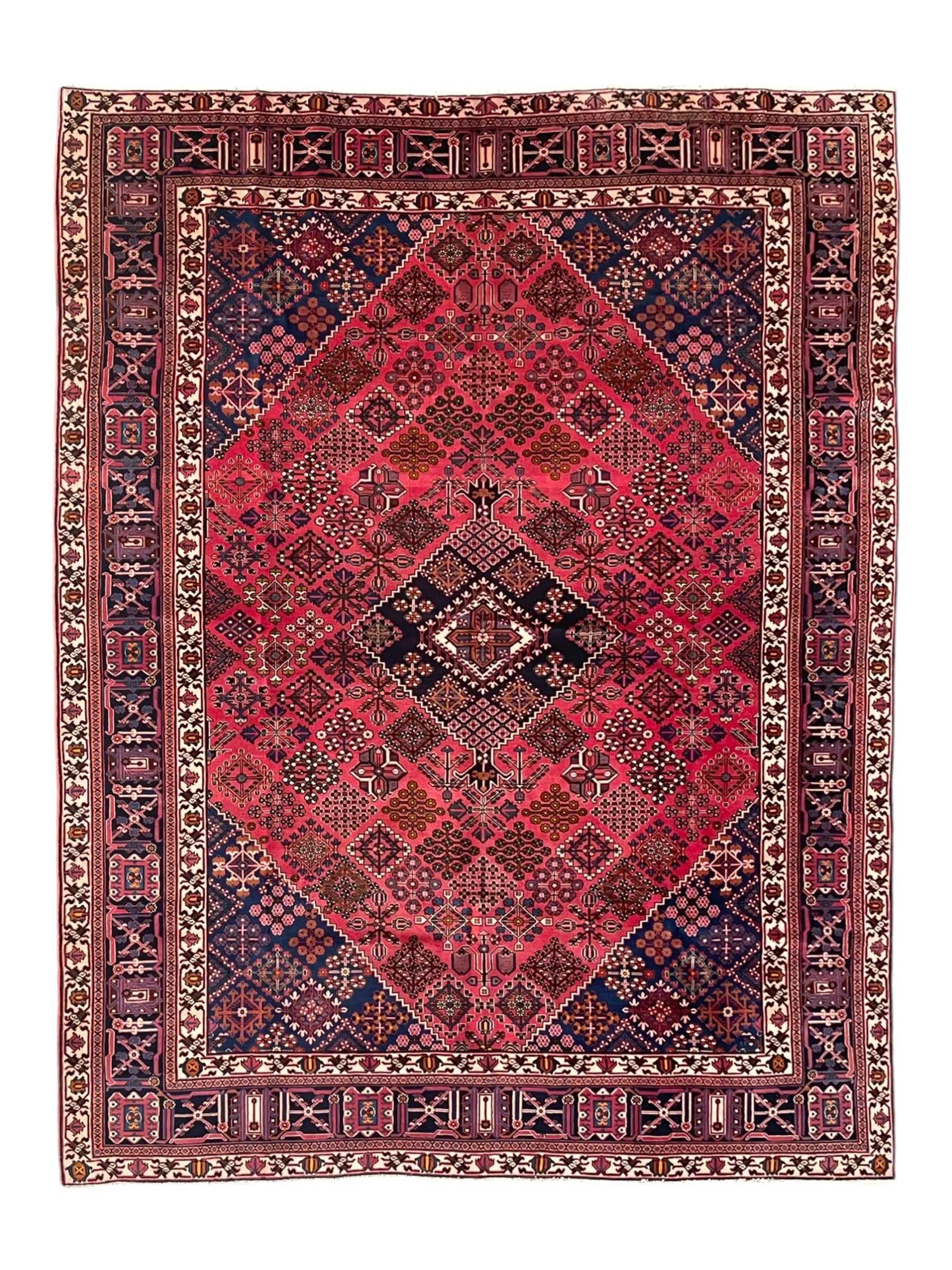 Persian Joshaghan red ground rug, the medallion, field and spandrels decorated with Pitrak and tree of life motifs, the border with repeating design decorated with stylised plant motifs, within guard stripes