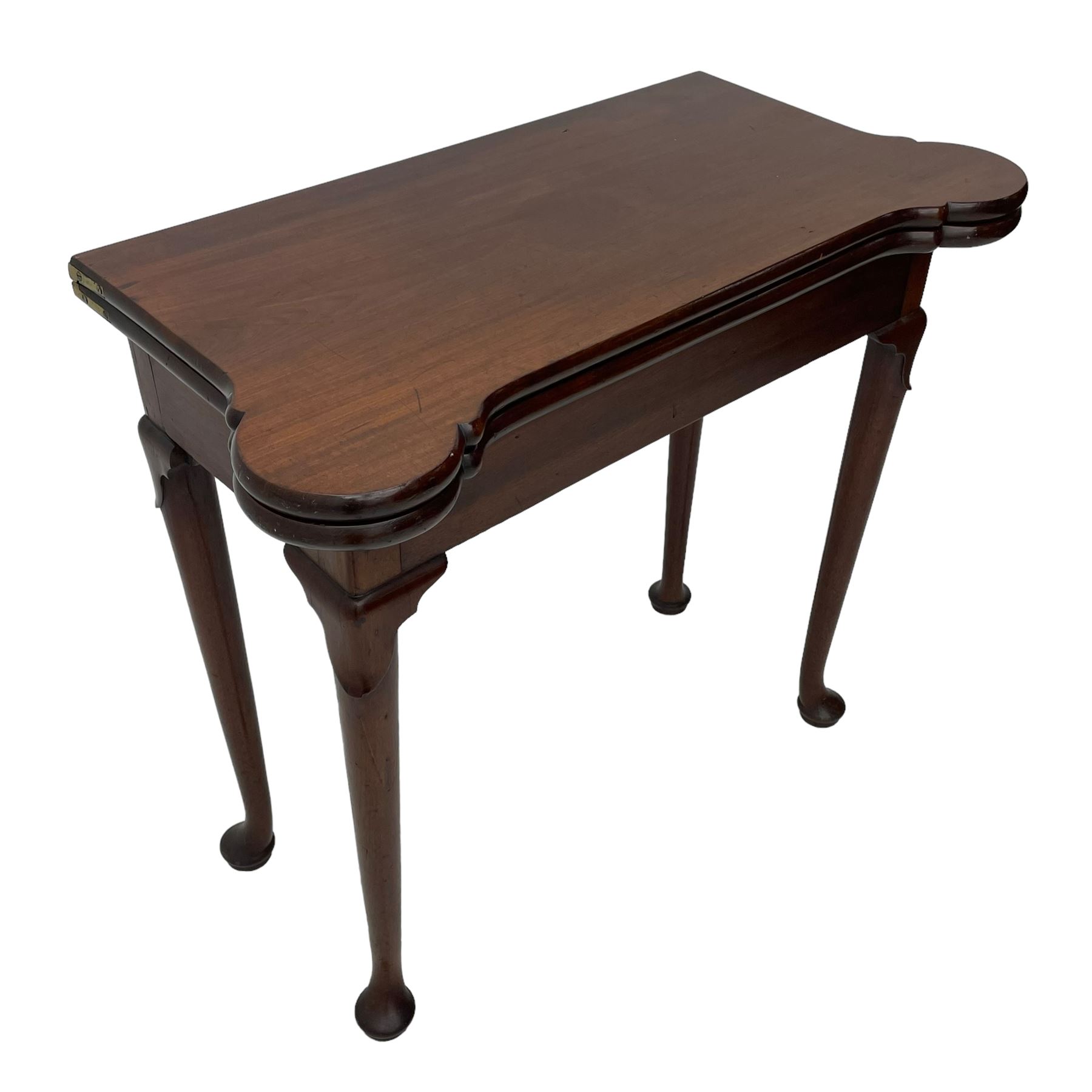 George III mahogany games table, the rectangular fold-over top with extending stepped rounded corners, opening to reveal baize lined interior with sunken counter wells, concertina action base, on lappet cabriole supports