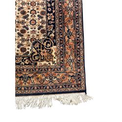 Indo-Persian Herati design ivory ground rug, central medallion on a field of repeating floral Herati motifs, peach ground border with repeating pattern, enclosed by guard stripes 