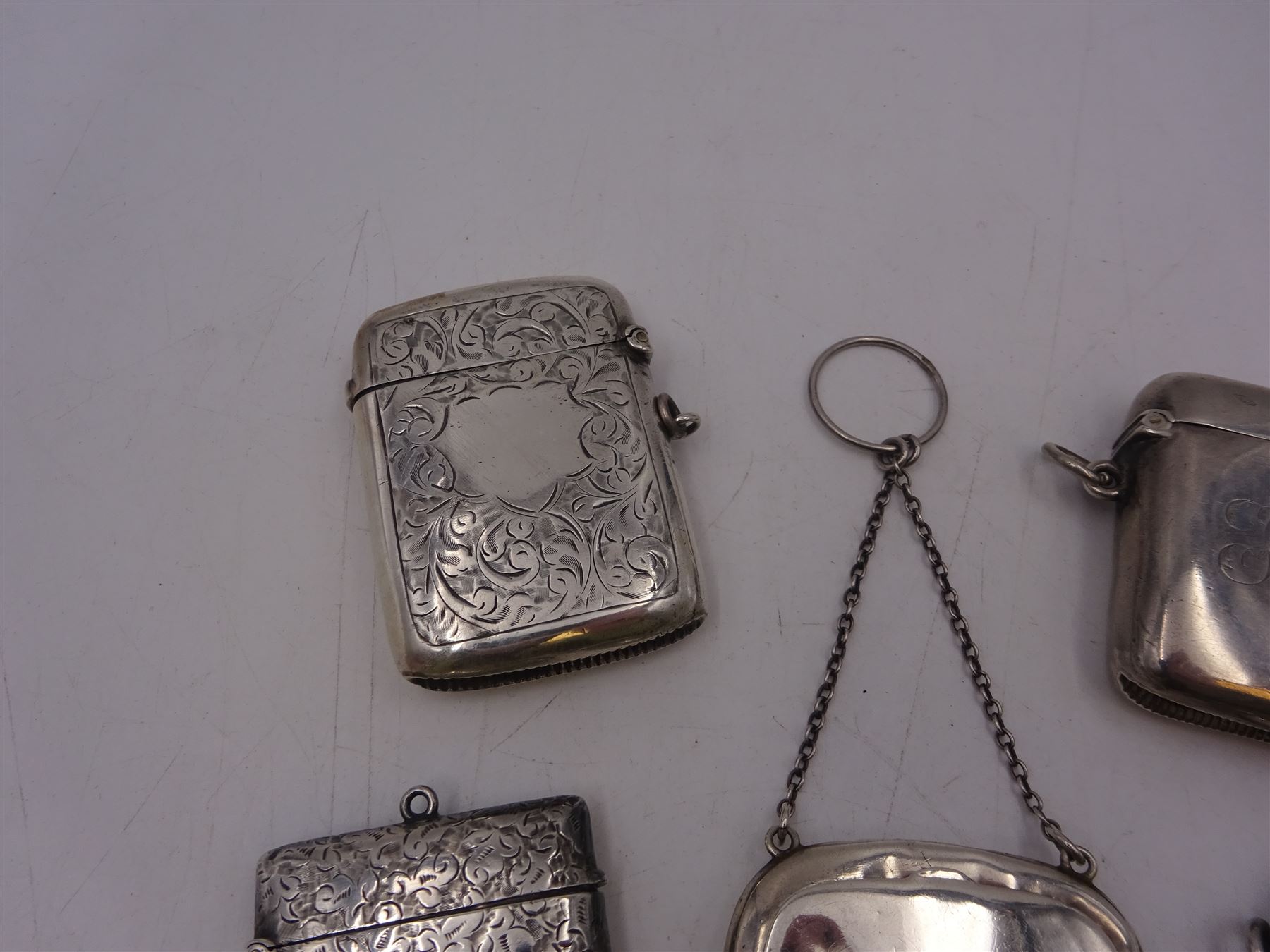 1920s silver miniature purse, engraved with triskelion symbol to hinged cover, hallmarked Adie & Lovekin Ltd, Birmingham 1920, together with five early 20th century silver vesta cases, all of typical form, engraved with foliate and scrolling details, all hallmarked