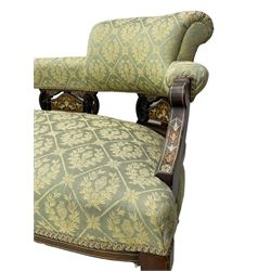 Late Victorian walnut salon settee or chaise lounge, double-ended with rolled back and curved end, upholstered in light aquamarine fabric with raised repeating lozenge pattern, decorated with laurel leaf wreaths and urns, three pierced splats carved with curled leaves, inlaid with dolphins and scrolled foliate motifs in simulated ivory and boxwood, on tapering ring turned supports with brass and ceramic castors (L166, D60, H70cm); together with matching tub-shaped armchair (W61cm, H73cm, D66cm)  