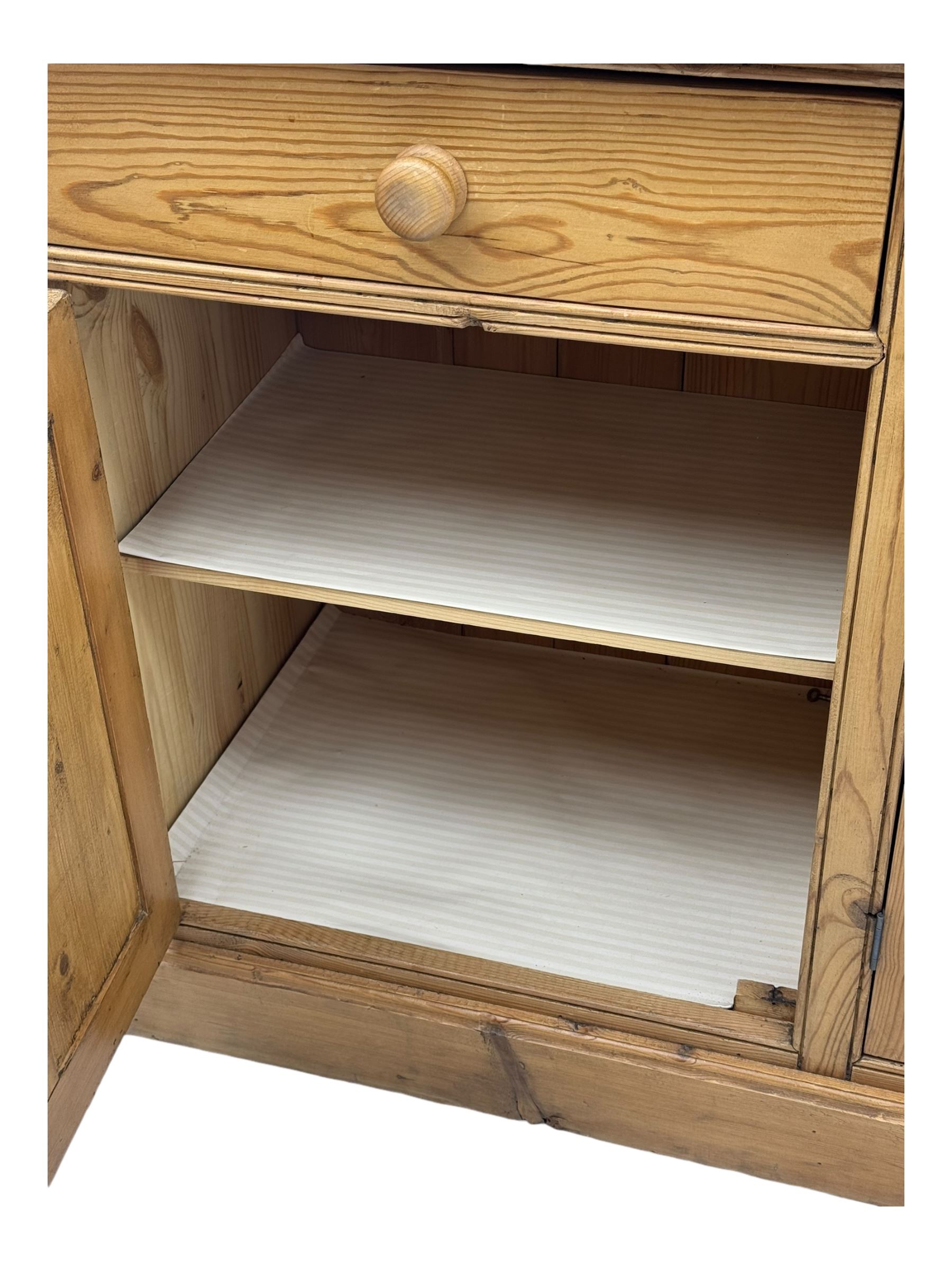 Large pine dresser, raised display cabinets over three drawers and three panelled cupboards, on plinth base