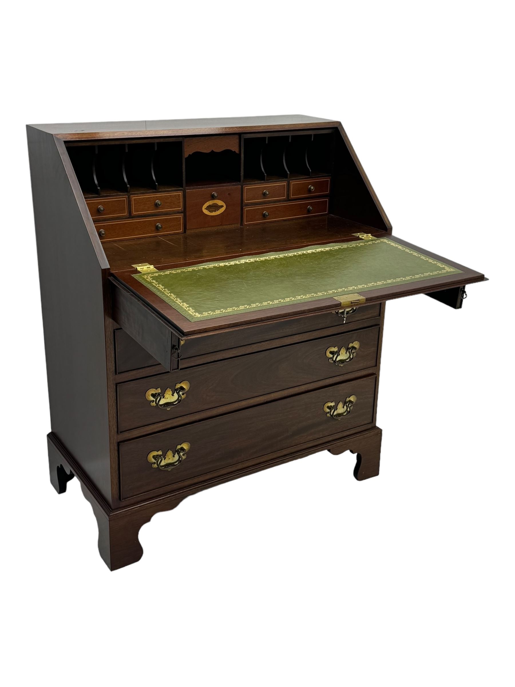 Mid-to-late 20th century inlaid mahogany bureau, inlaid floral medallion to the top, the fall front opening to reveal fitted interior with pigeonholes, small drawers and central cupboard, green inset writing surface with gilt tooling, four drawers below with brass handles, raised on shaped bracket feet