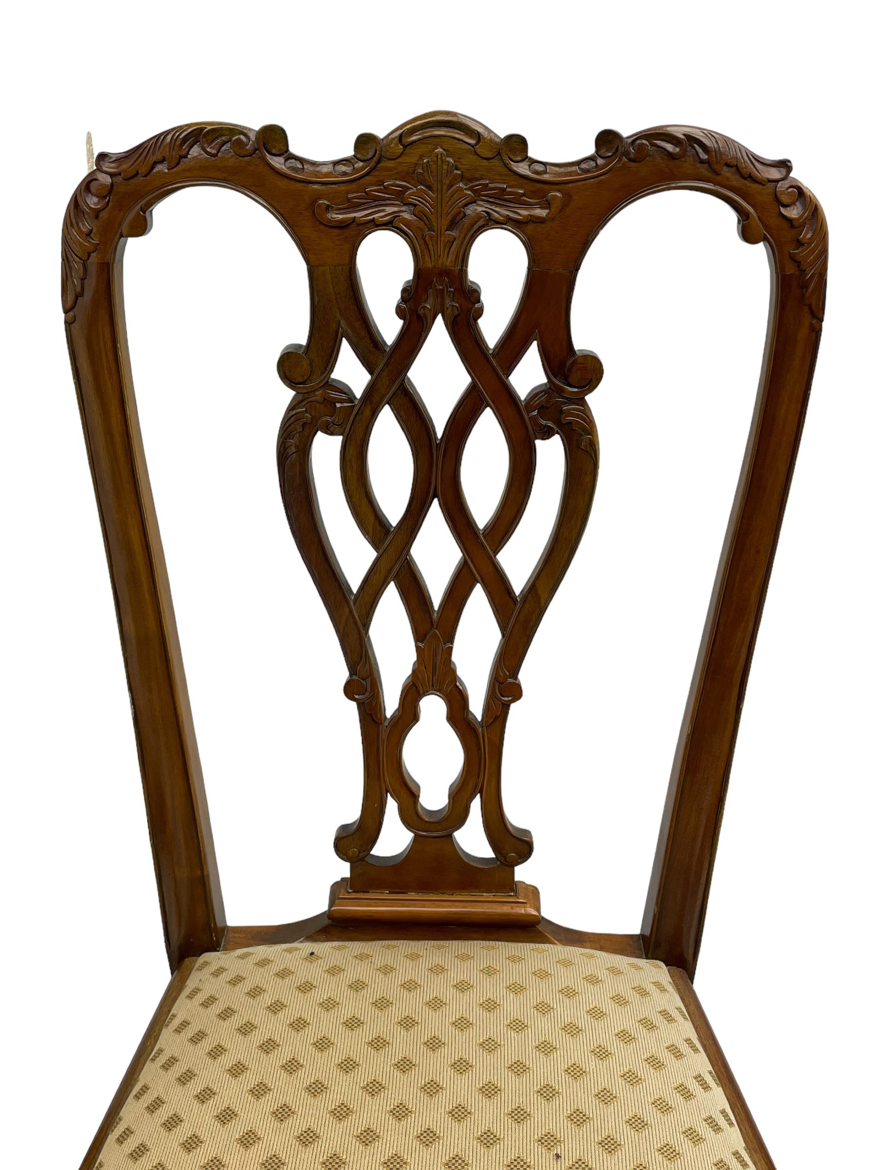 Set of twelve Chippendale design mahogany dining chairs, shaped cresting rail carved with foliage and C-scrolls, pierced interlaced splat with curled leaf decoration, upholstered drop-in seat, moulded seat rails, on scrolled acanthus carved cabriole supports with ball and claw feet 