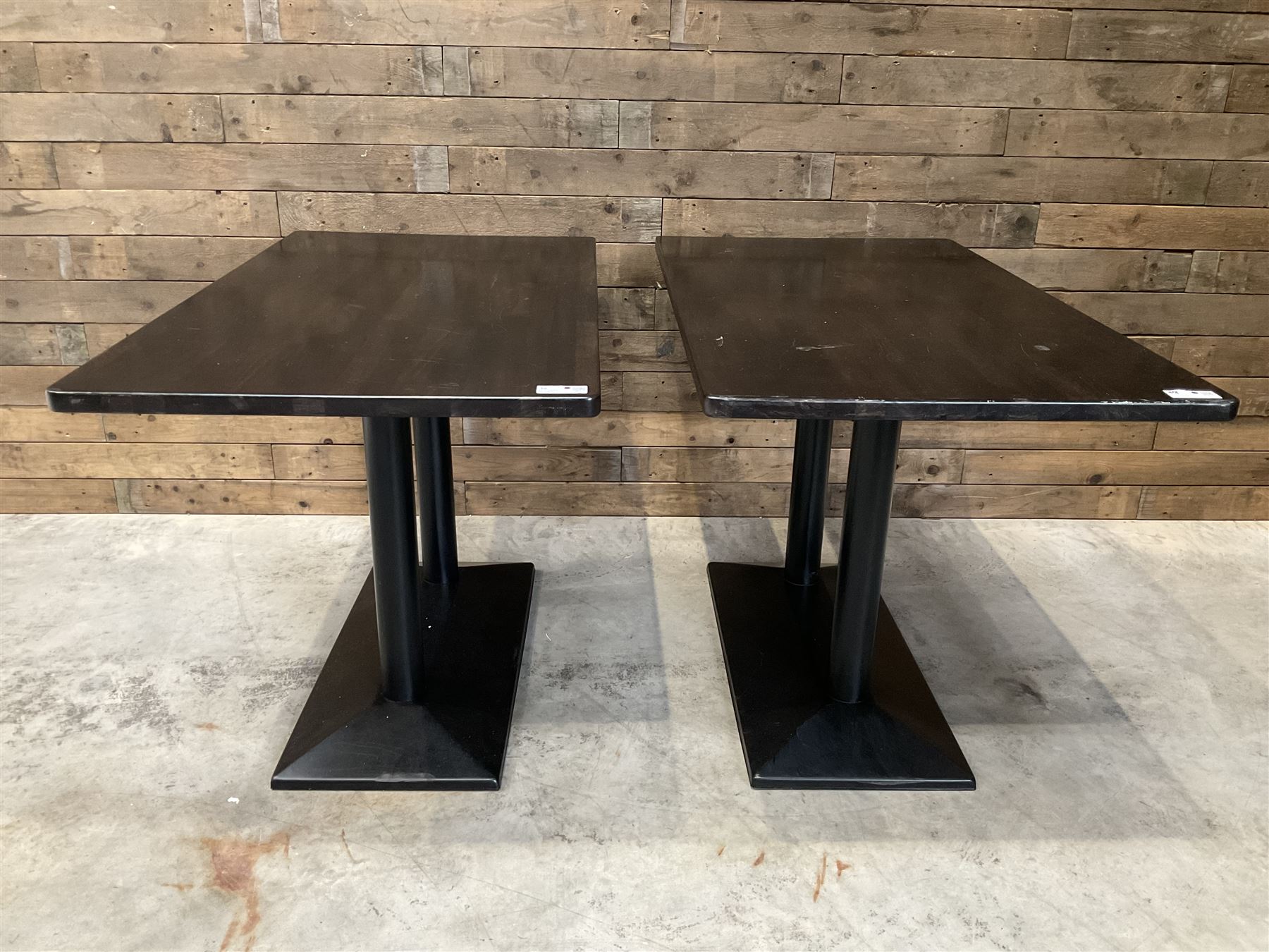 Two dark walnut rectangular console tables, on black metal bases