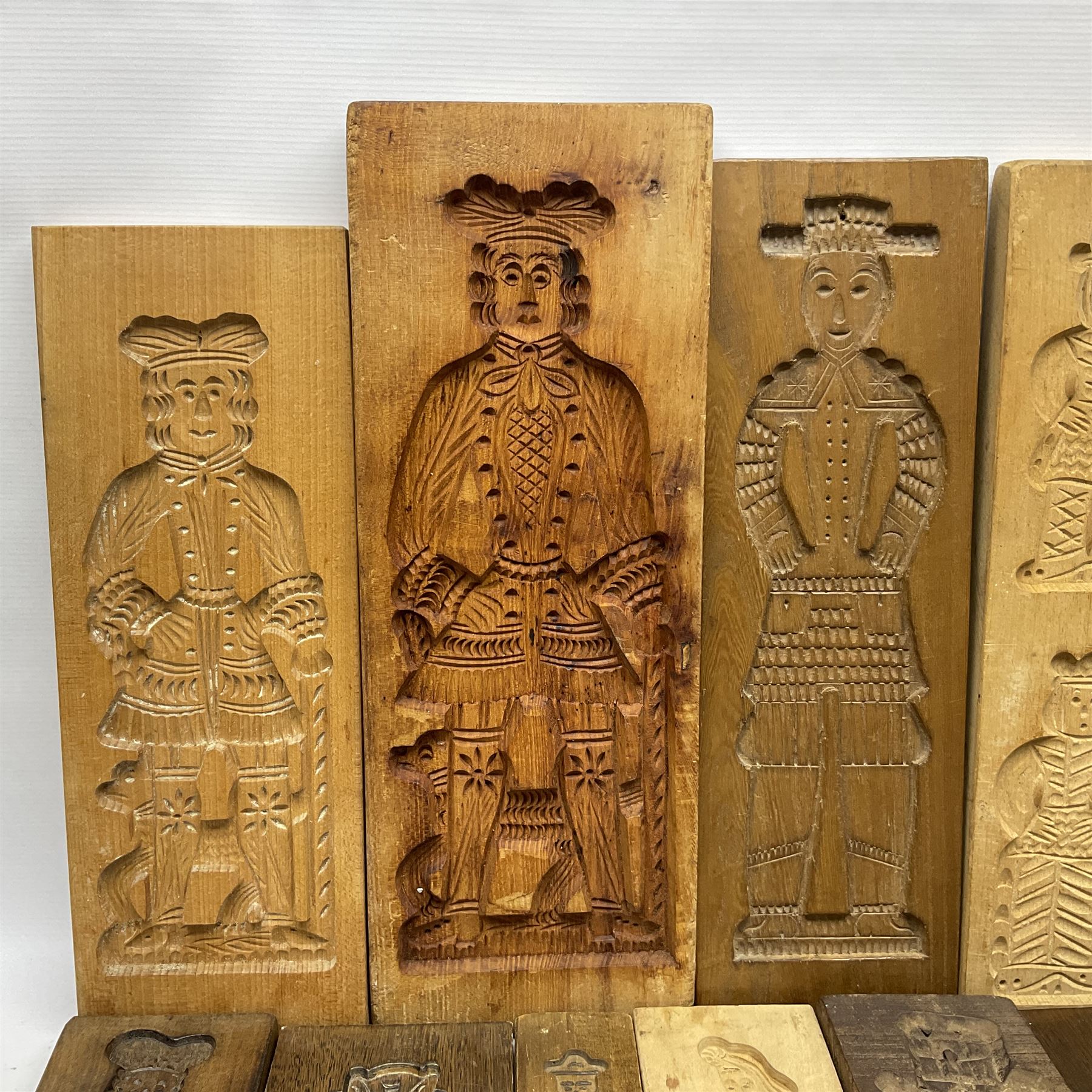 Collection of 20th century beech and other hardwood Dutch folk art Speculaasplank or biscuit moulds, most examples typically carved with figures in traditional dress, tallest H52cm