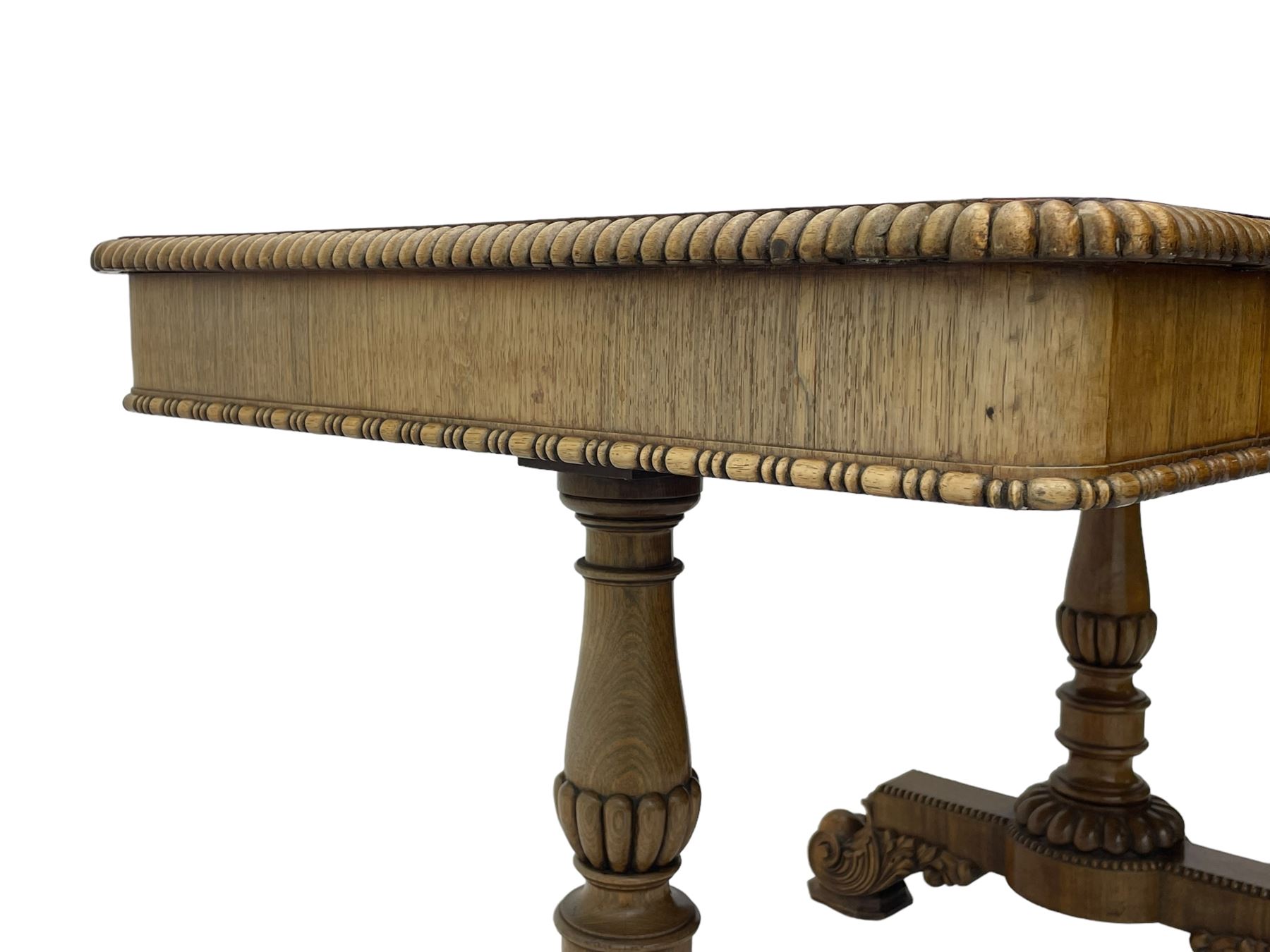 Early 19th century Regency rosewood writing table, rectangular top with inset leather writing surface and gadroon moulded edge, fitted with single frieze drawer, on twin turned pillar supports with lobe carved balusters, on platforms with beaded edge, acanthus scroll carved feet