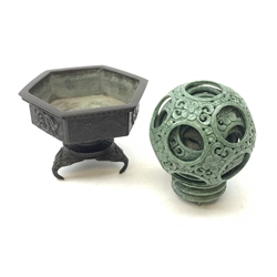 A carved soapstone puzzle ball, with seven concentric bands, upon a soapstone stand, including stand H15.5cm, together with a Japanese bronzed planter on stand, of hexagonal form, decorated with fret pattern and phoenixes, H12.5cm. 