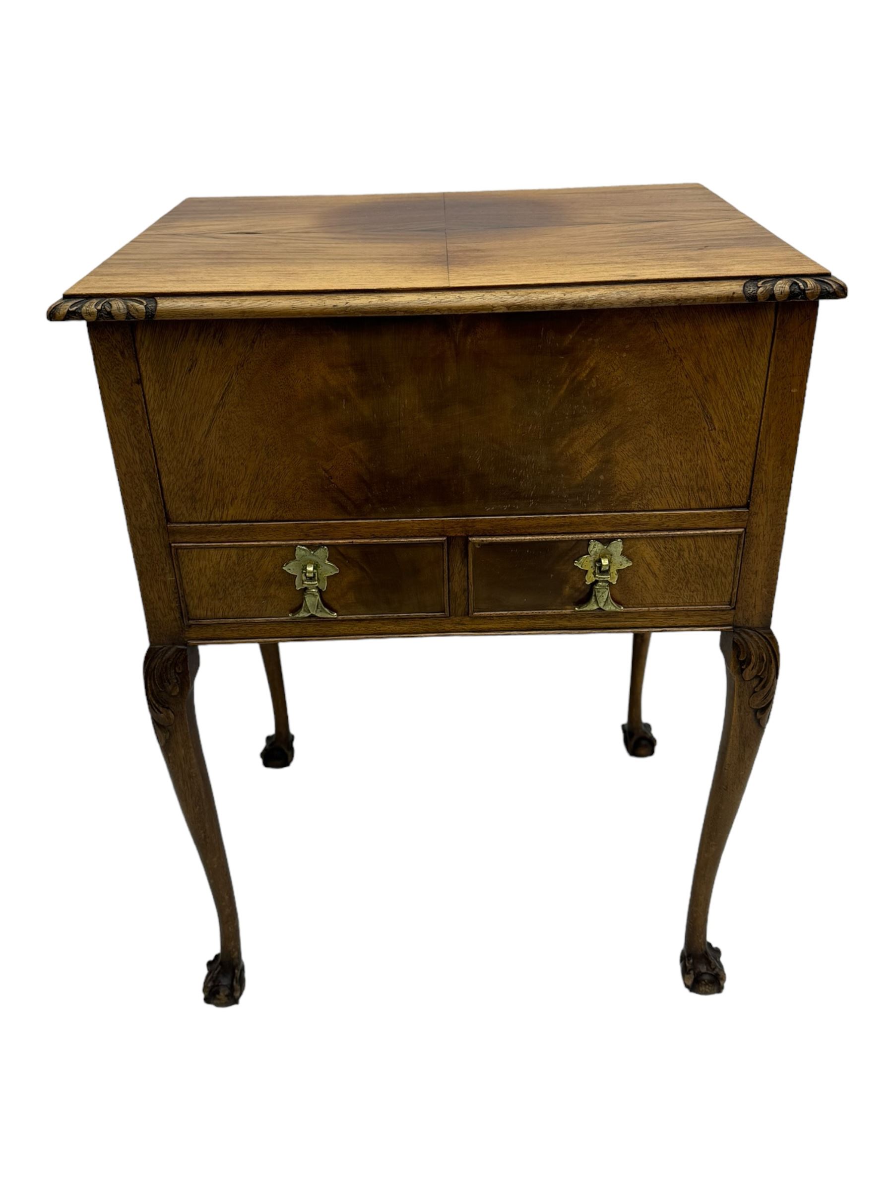 Early 20th century mahogany work table, hinged top enclosing satin-lined compartment with pincushion and pockets, lower section fitted with two drawers with dividers, on cabriole supports with carved knees and claw feet