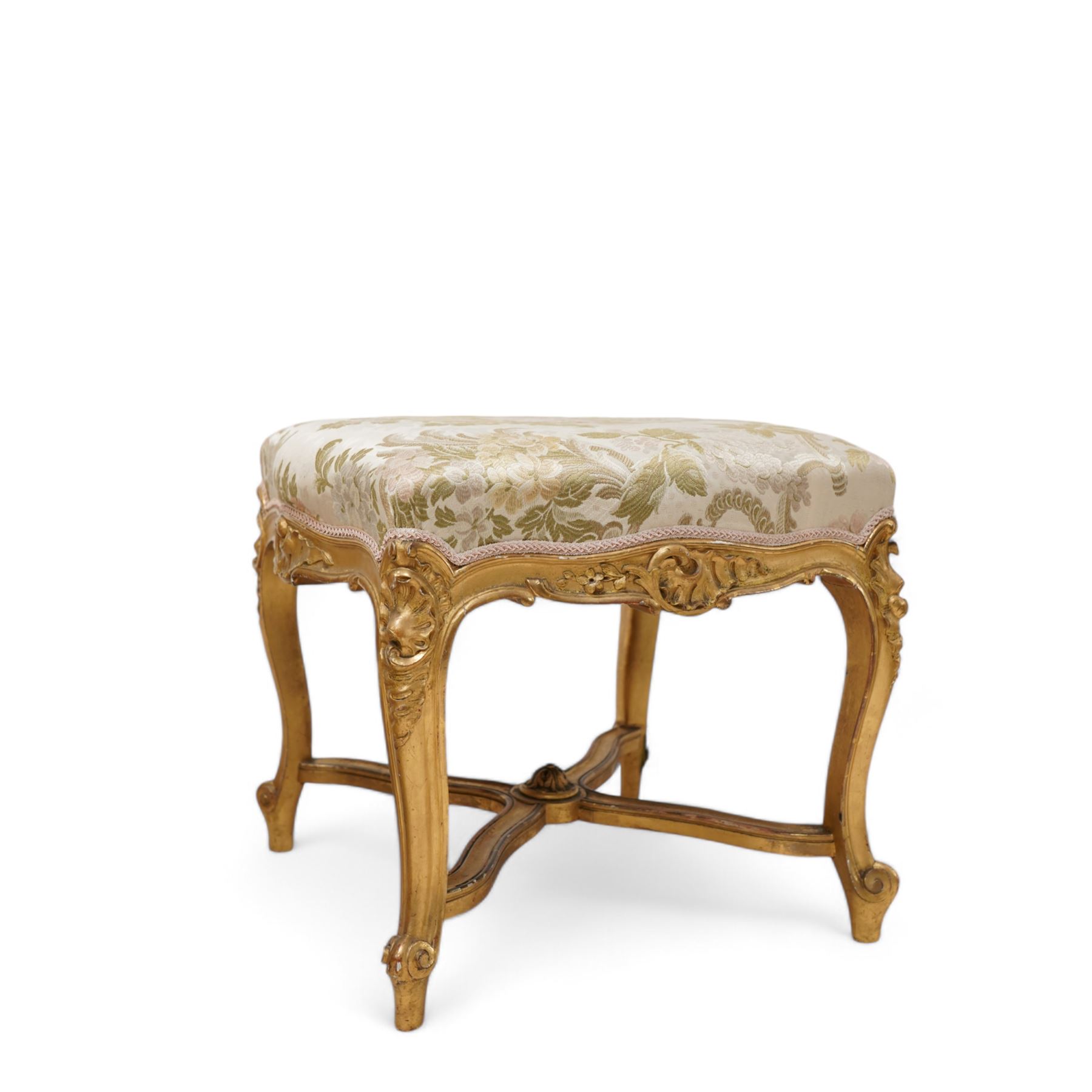 James Shoolbred & Co. (London: 1814-1934) - pair of late 19th century giltwood French design stools, shaped seat upholstered in floral pattern fabric, on shell carved cabriole supports with scrolled terminals, united by shaped X-frame stretchers, with ivorine maker's label inscribed 'Jas Shoolbred & Co.' 