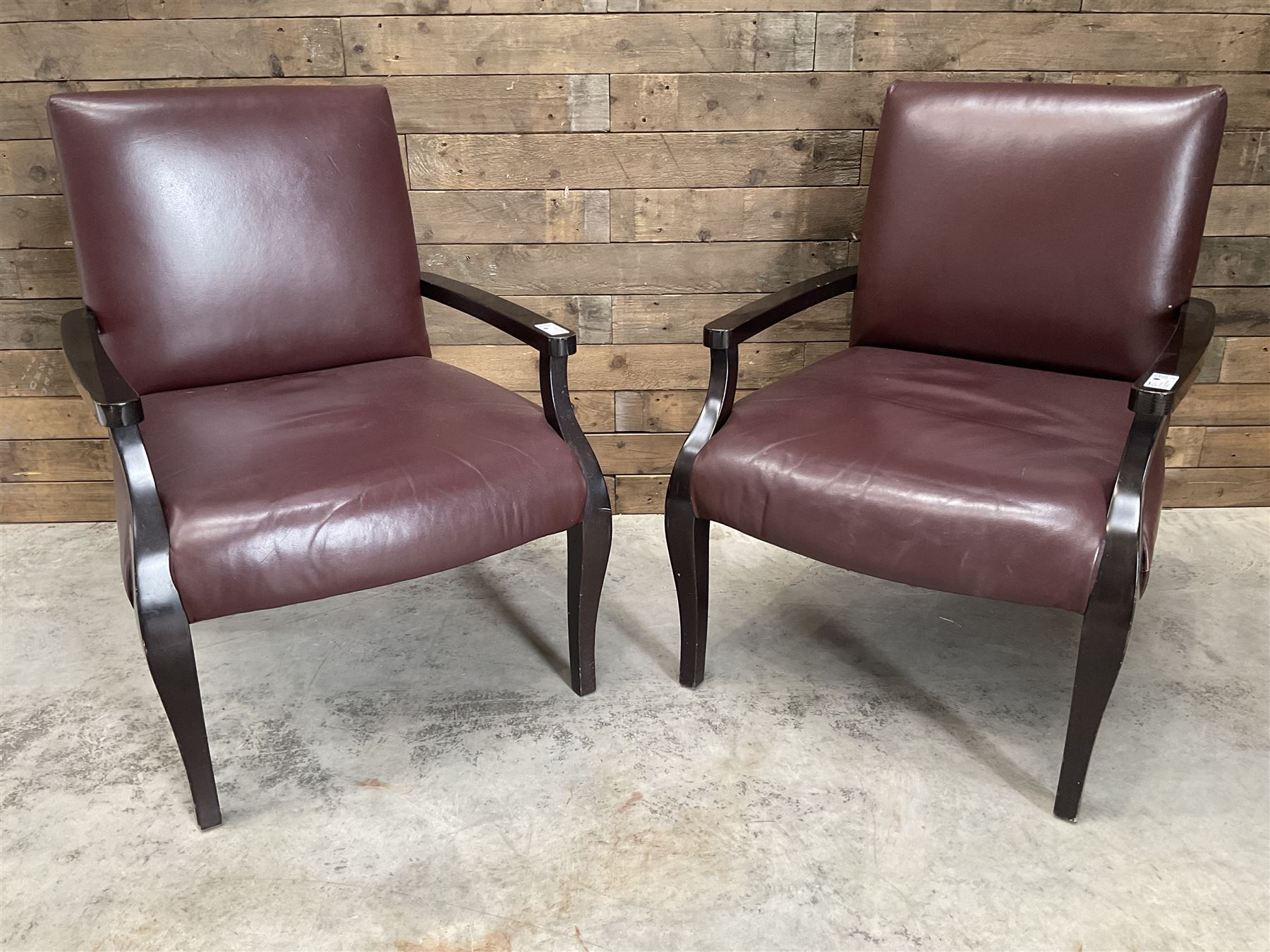 Two rosewood framed armchairs, upholstered in brown leather