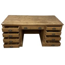 20th century waxed pine kneehole desk, rectangular top over nine drawers with cup handles, on moulded plinth base