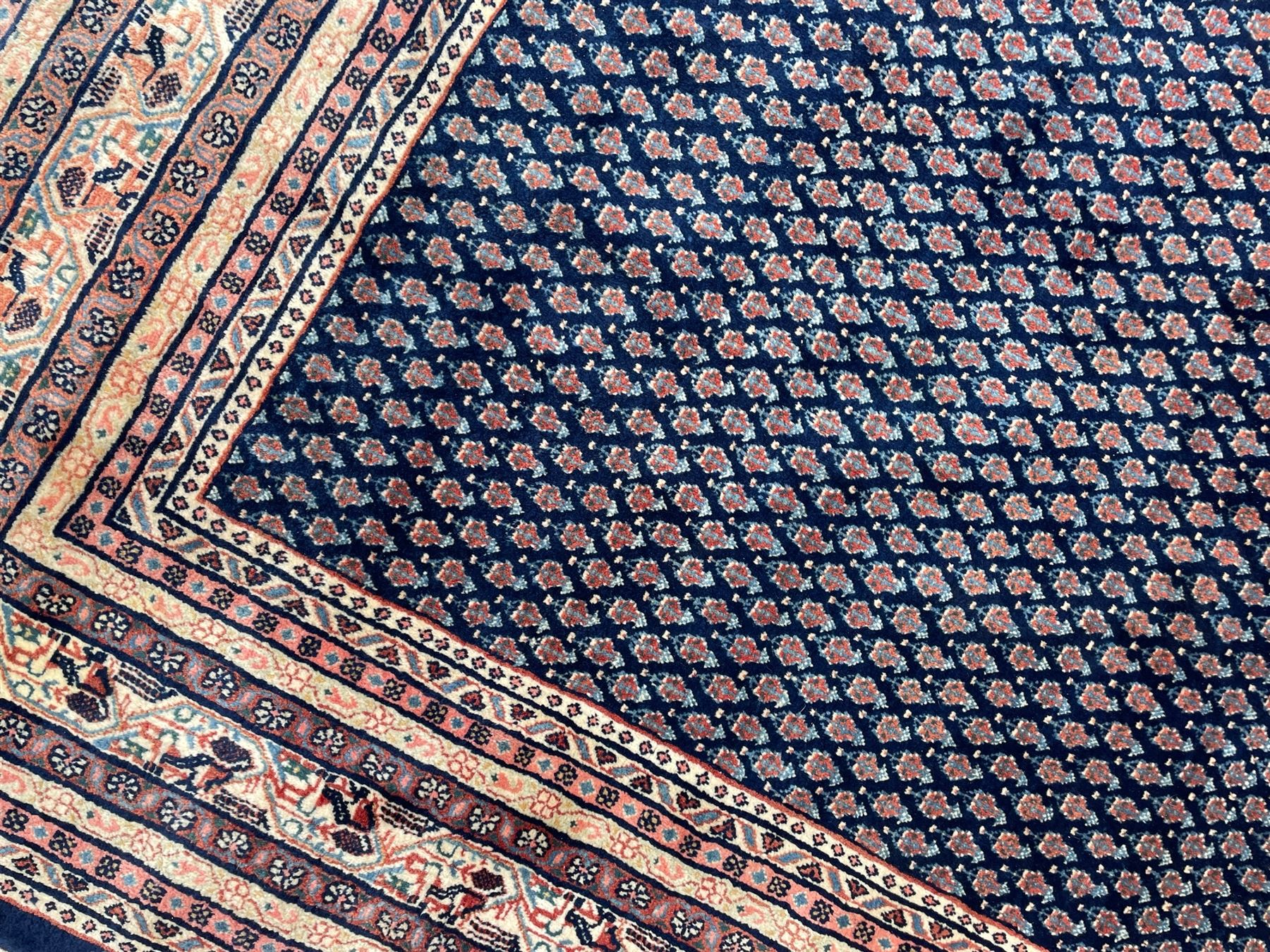 Large North-West Persian Arrak indigo ground carpet, the field decorated all-over with small Boteh motifs, multiple band border decorated with repeating geometric designs