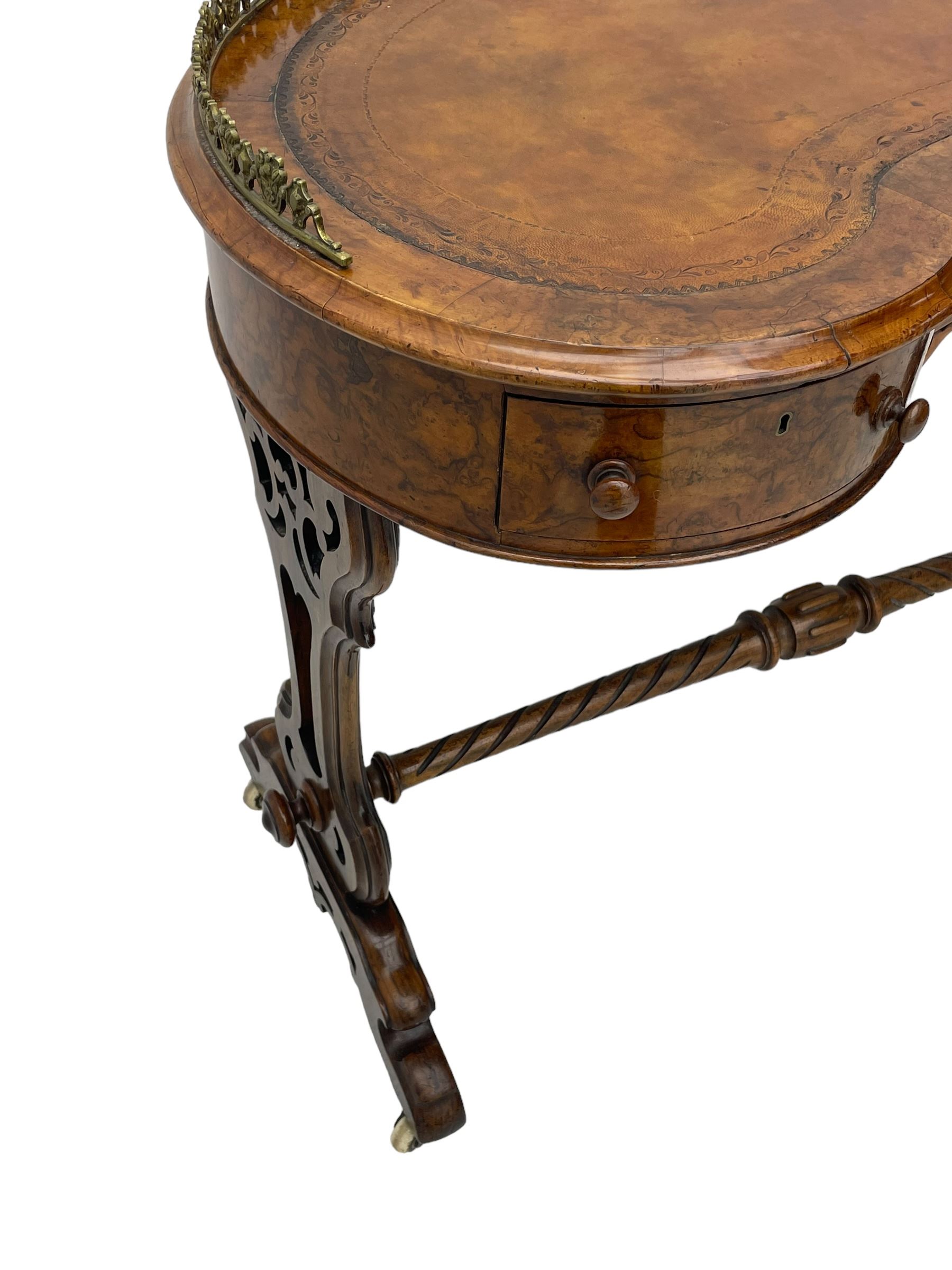 Victorian walnut kidney-shaped writing desk, moulded top with floral cast brass gallery and inset leather writing surface, fitted with three frieze drawers with turned handles, shaped and pierced end supports on raised platforms terminating to splayed feet, united by twist turned and lobe carved stretcher, brass and ceramic castors 