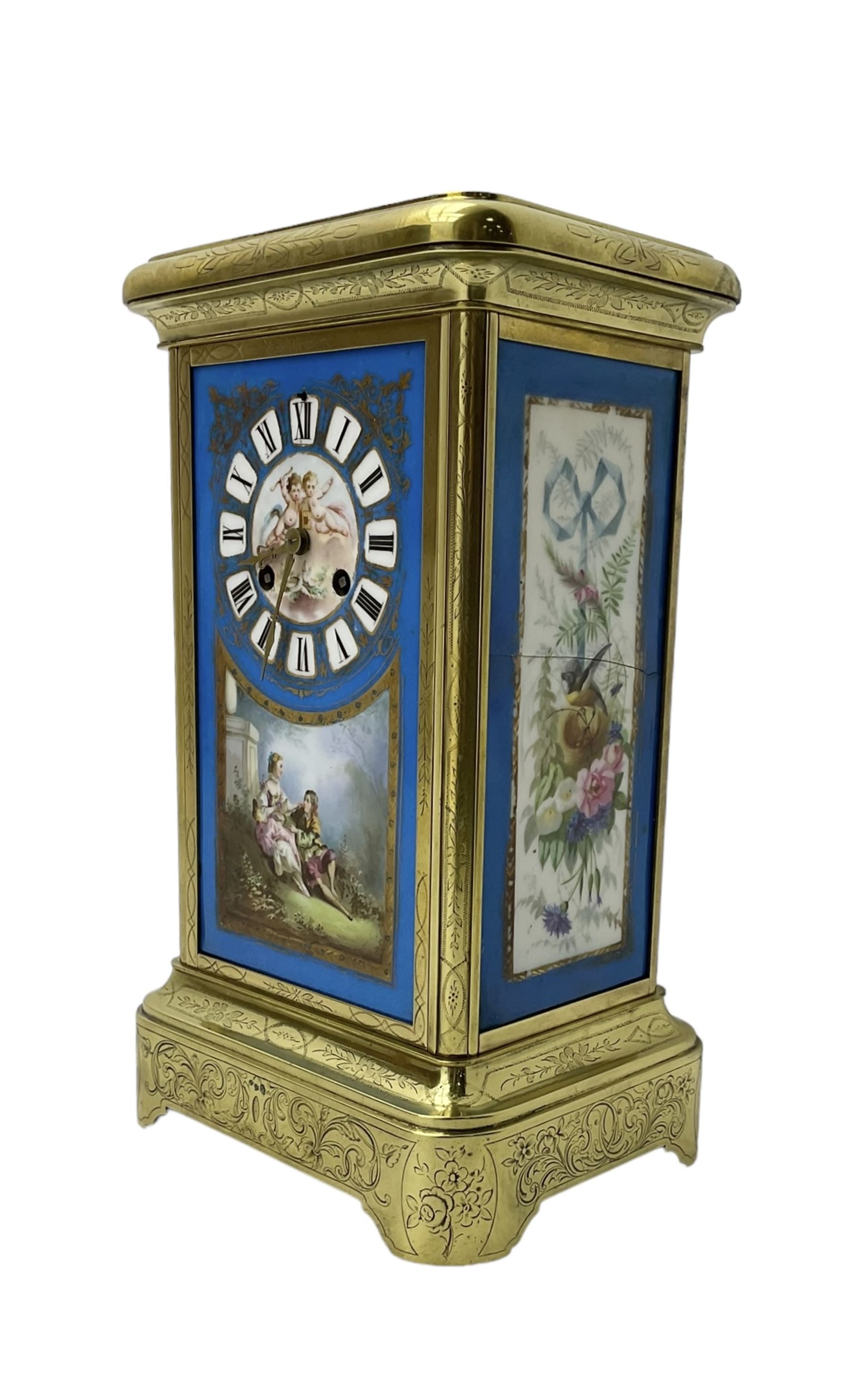 French - late 19th century 8-day mantle clock in an engraved brass corniche case with three rectangular porcelain panels decorated in the romantic Sevres style, dial with brass hands, cartouche Roman numerals and a depiction of cupid to the dial centre, rack striking movement sounding the hours and half hours on a bell. With pendulum.