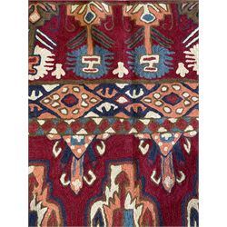 Caucasian design crewelwork hanging, crimson ground, the field decorated with geometric designs, the wide guard band with repeating stylised plant  motifs