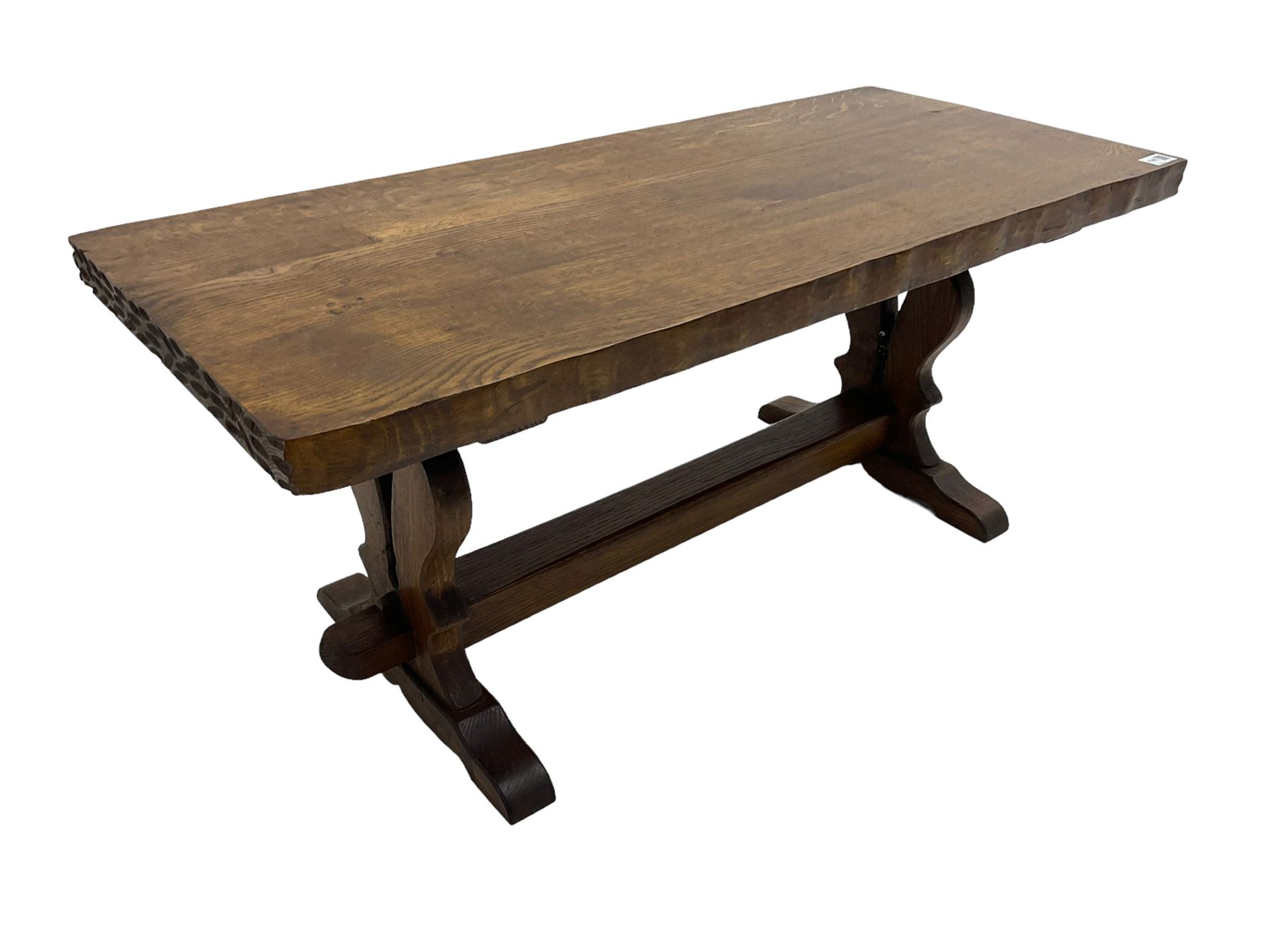 Solid oak coffee table, rectangular waved cut top with tooled ends, on shaped and pierced end supports joined by pegged stretcher 