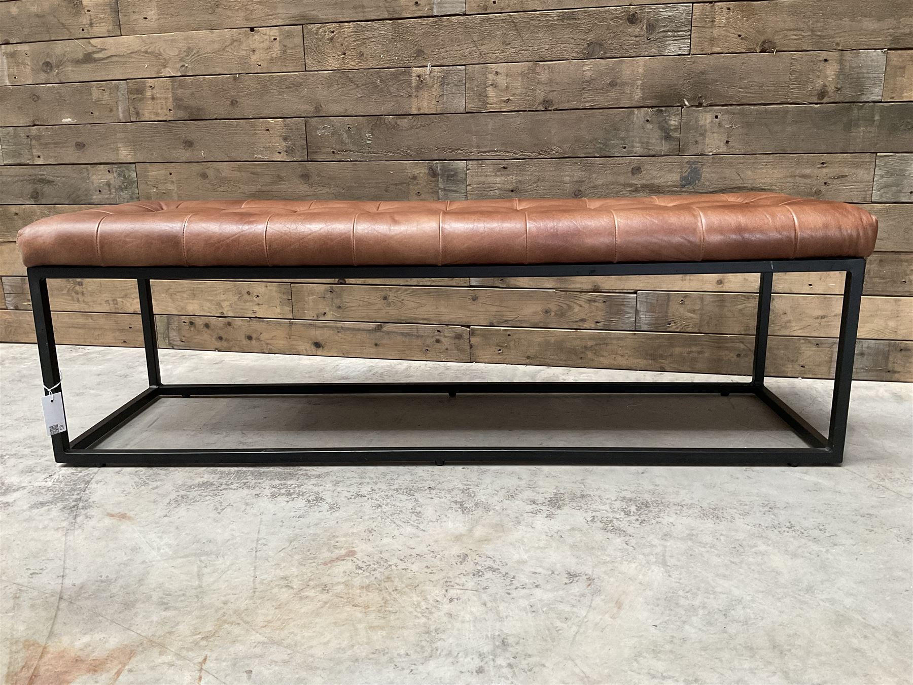 Two rectangular metal framed benches, upholstered in buttoned tan leather