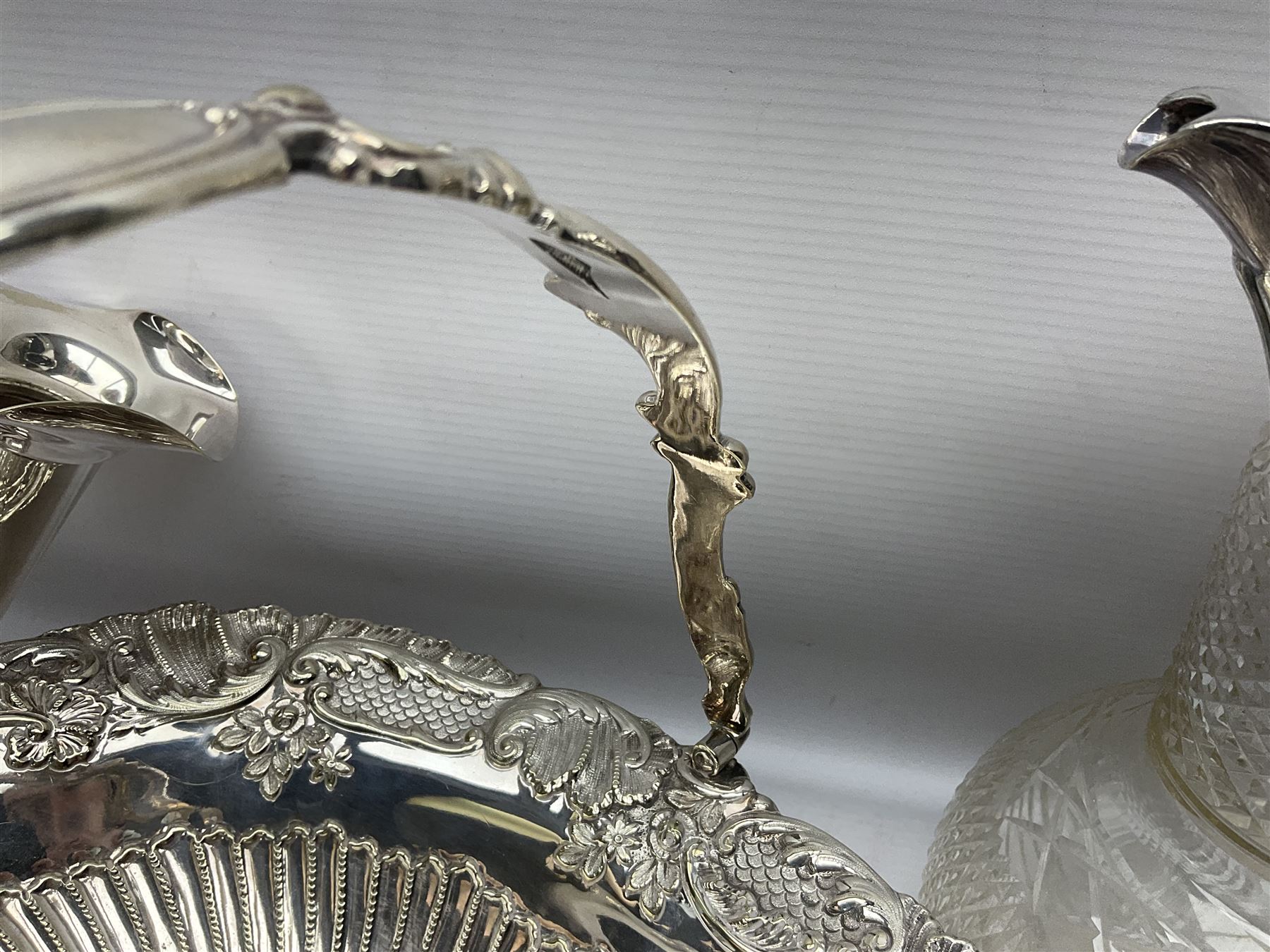 Silver plated three branch epergne, together with a silver plated cut glass claret jug, and silver plated embossed swing handled basket, epergne H30.5cm