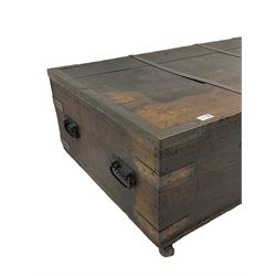 Early 19th century oak low blanket chest, metal strapped and bound, two carrying handles to either end, on castors