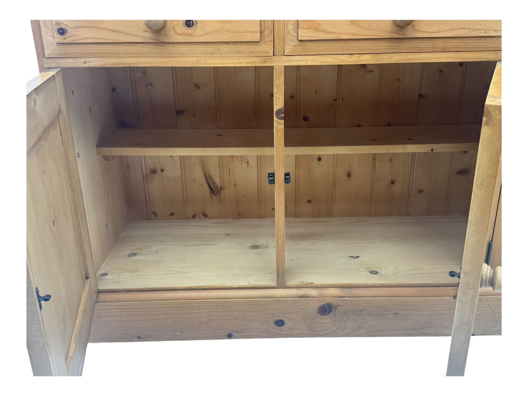 Large traditional pine dresser, shaped cornice over three open shelves, base fitted with four drawers above four panelled cupboards, each with turned wooden knobs, on plinth base