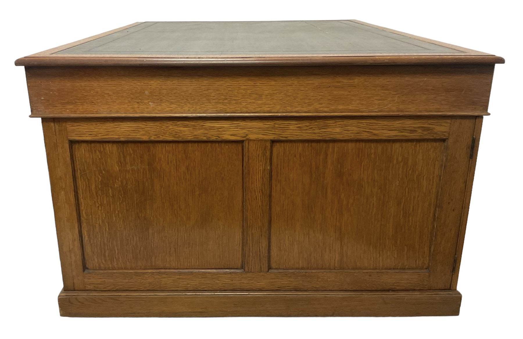 Late 19th century twin pedestal oak partner's desk, rectangular top with inset green leather writing surface, fitted with nine graduating drawers to each side, the rear drawers enclosed by panelled cupboards