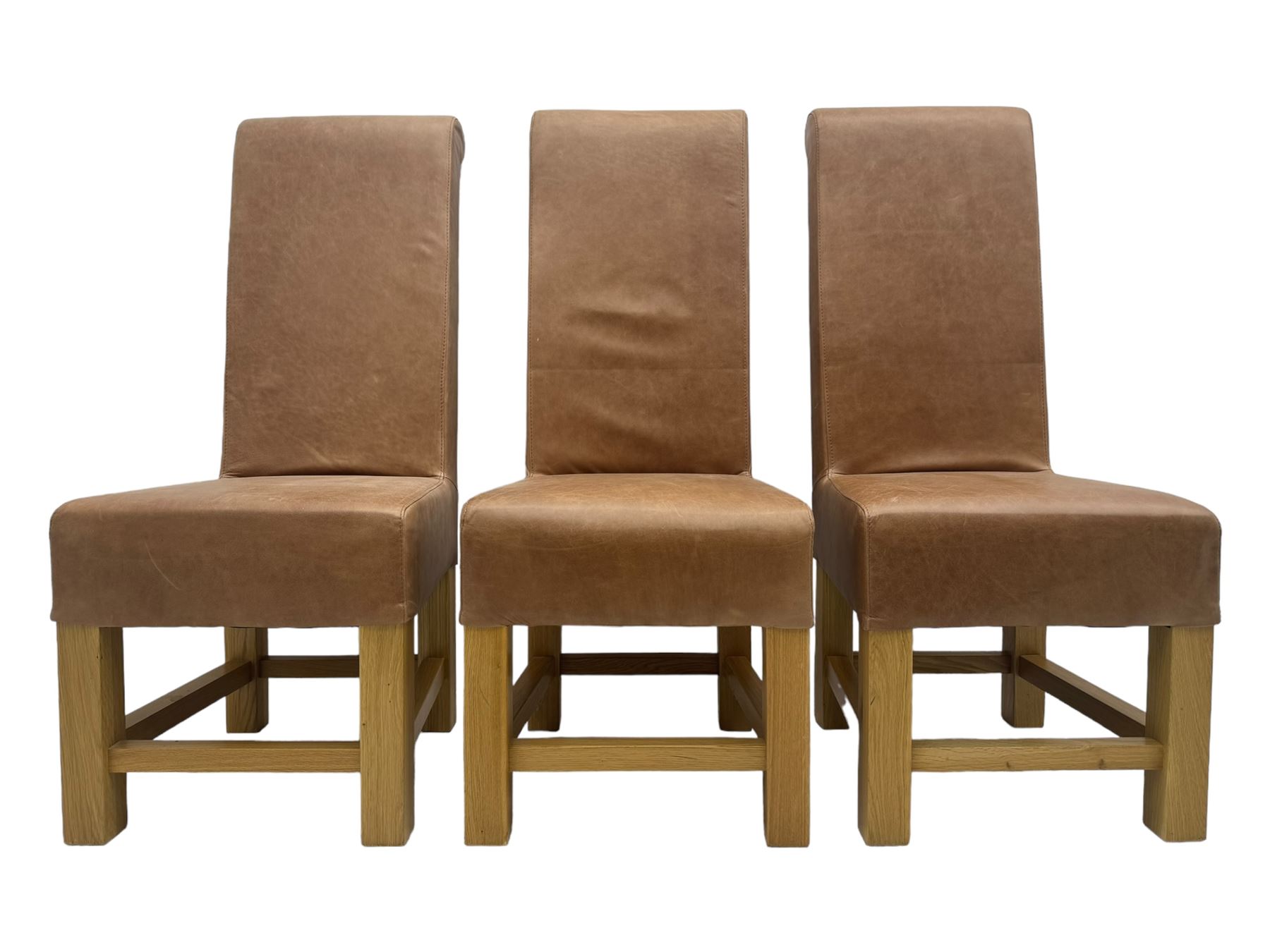 Set of six contemporary light oak dining chairs, each with high back and seat upholstered in pale tan leather, on square supports connected by H-stretcher