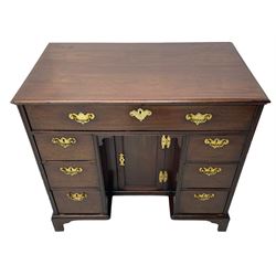 George III mahogany kneehole desk, moulded rectangular top over one long drawer, six short drawers and recessed panelled cupboard, cock-bead moulded frame, fitted with shaped brass handle plates with engraved decoration, on bracket feet 