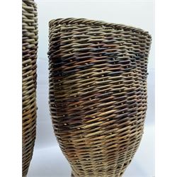 Two rattan baskets, of circular abstract form, together with two crook walking stick, basket H62cm 