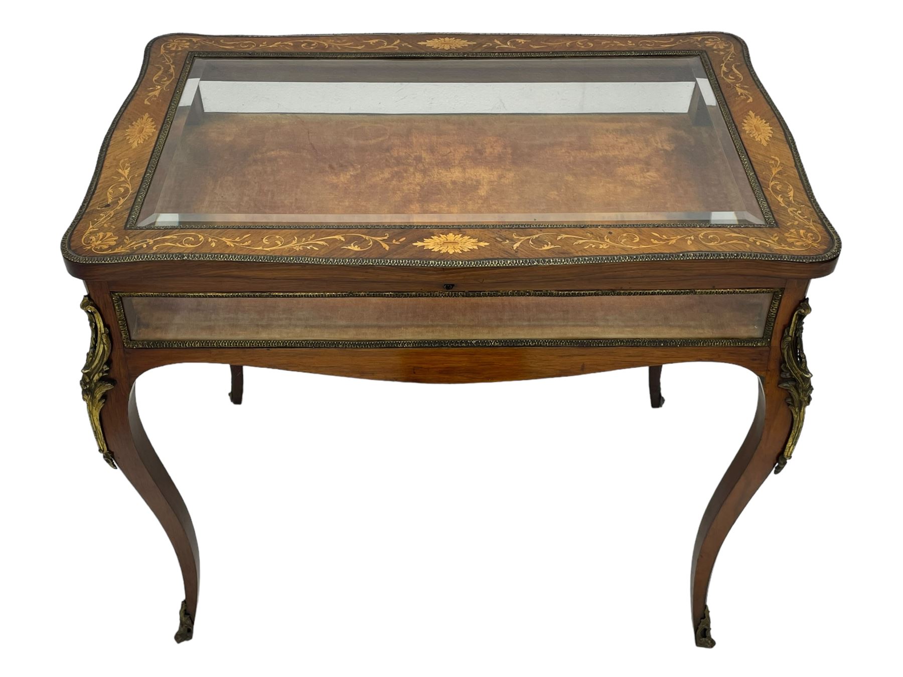 Victorian inlaid rosewood bijouterie table cabinet, shaped form, enclosed by hinged bevel glazed lid with shell and floral inlays, fabric lined interior, glazed sides within foliate cast gilt metal edging, on cabriole supports with floral cast gilt metal mounts and terminal caps 