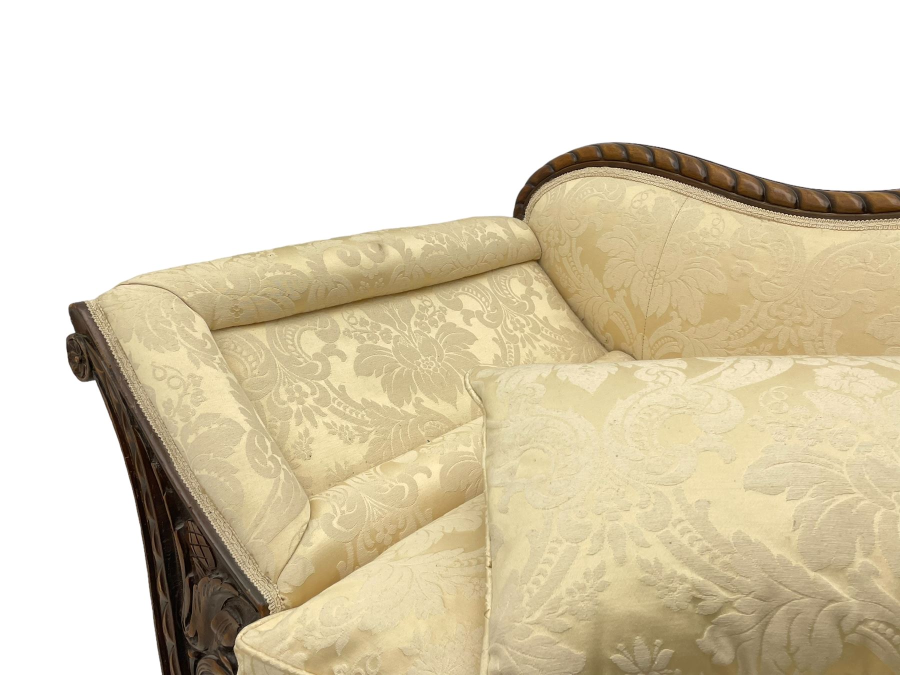 Victorian design walnut framed settee, shaped camelback with gadroon carved edge and central feather motif, upholstered in cream damask fabric with scrolling floral pattern, S-scroll arm facias carved with flower head and curled leaves, feather carved C-scroll splayed feet 